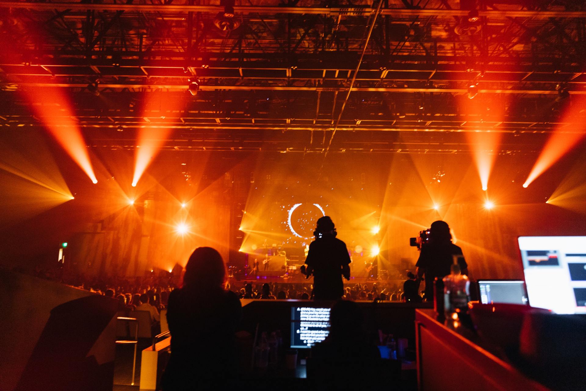 A group of people are standing in front of a stage at a concert.