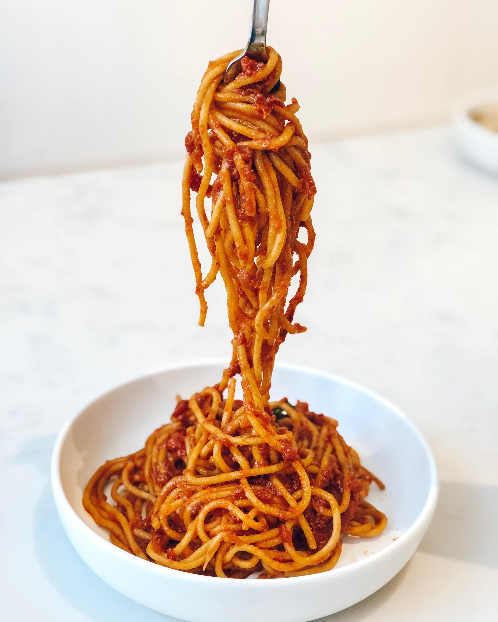 A bowl of spaghetti with a fork sticking out of it