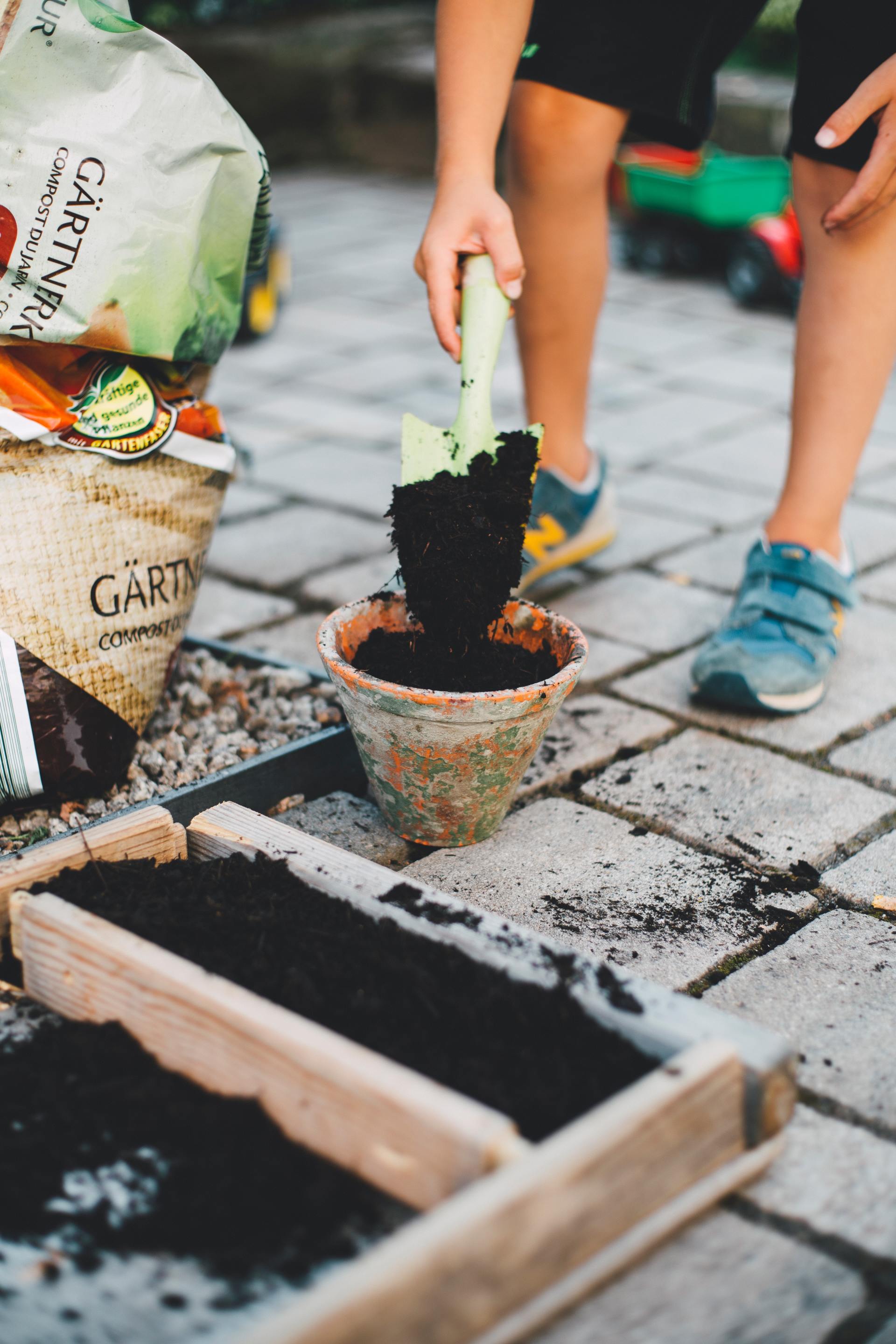 person placing soil in planter