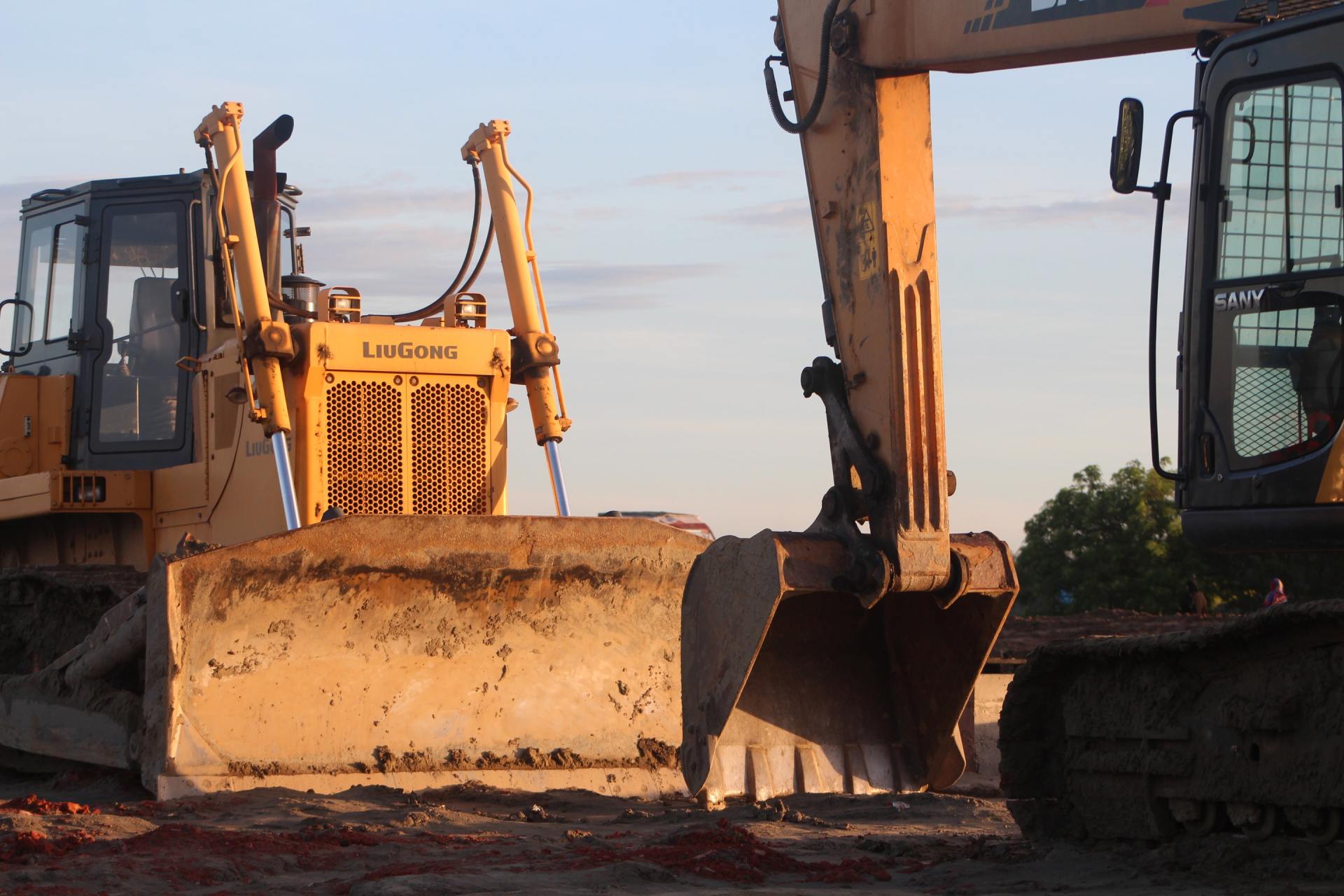 A bulldozer and an excavator are parked next to each other