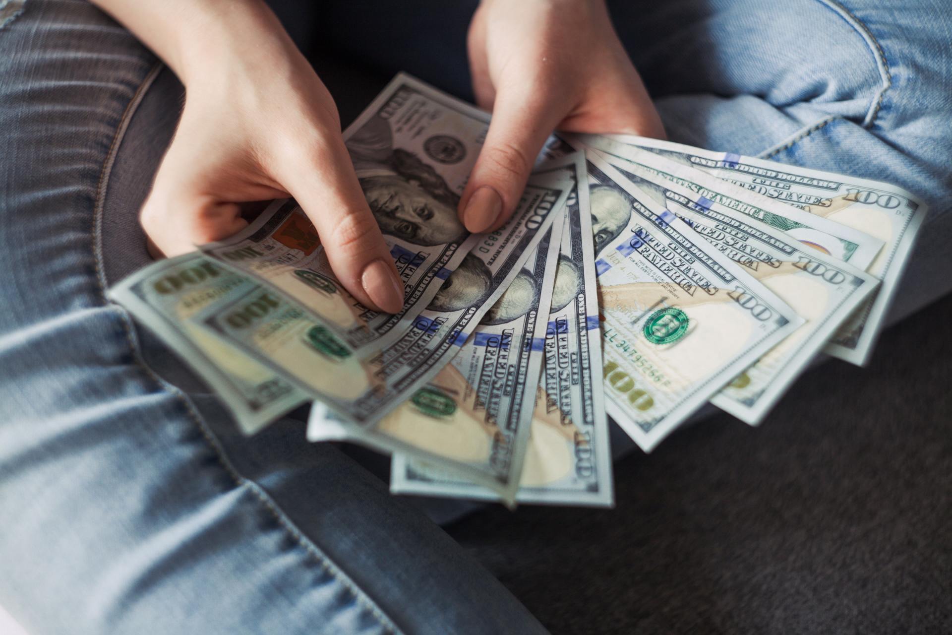 Woman hold a sheave of 100 dollar bills