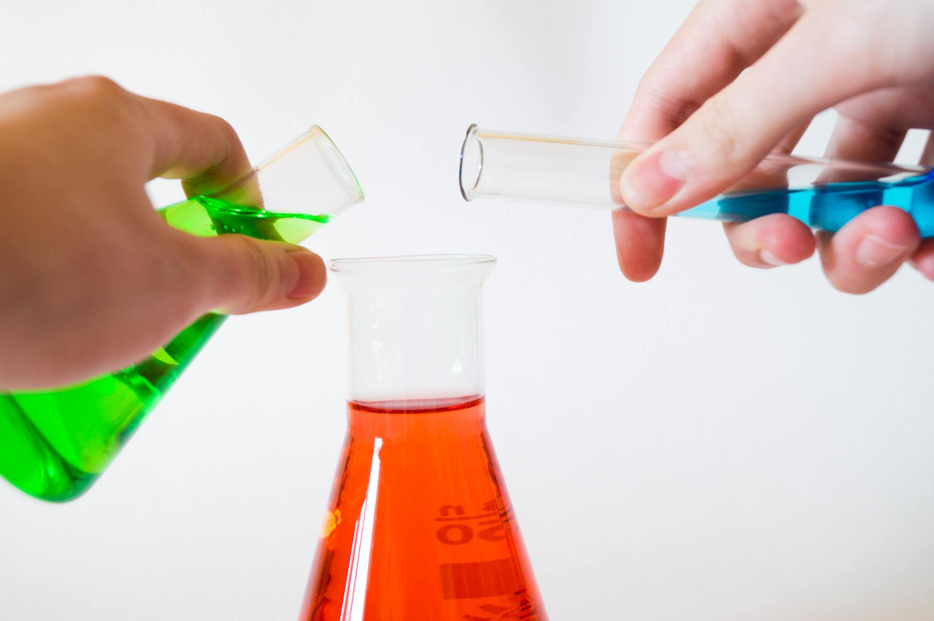 Photo of two test tubes being poured into a scientific flask