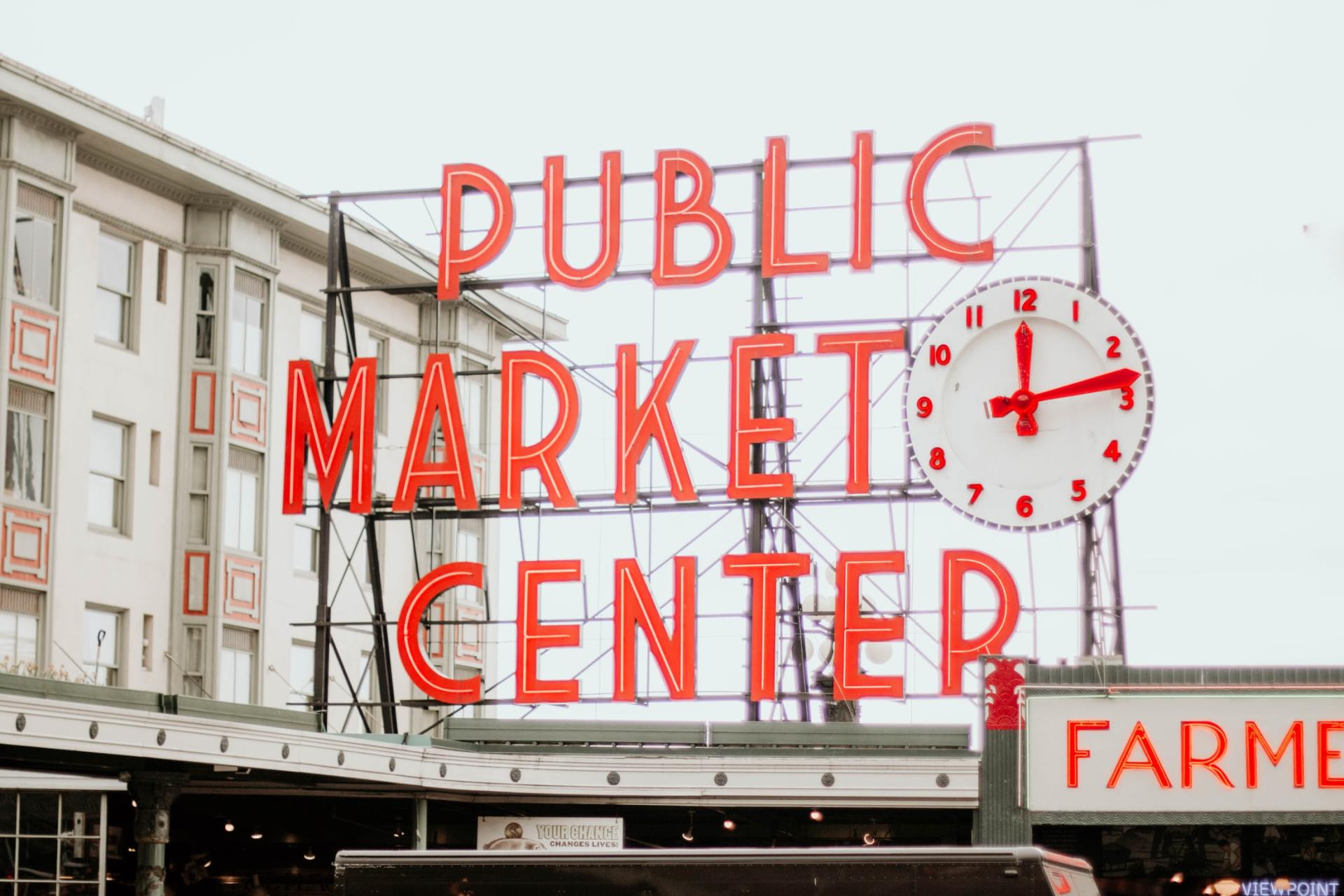 a sign for the public market center with a clock on it .