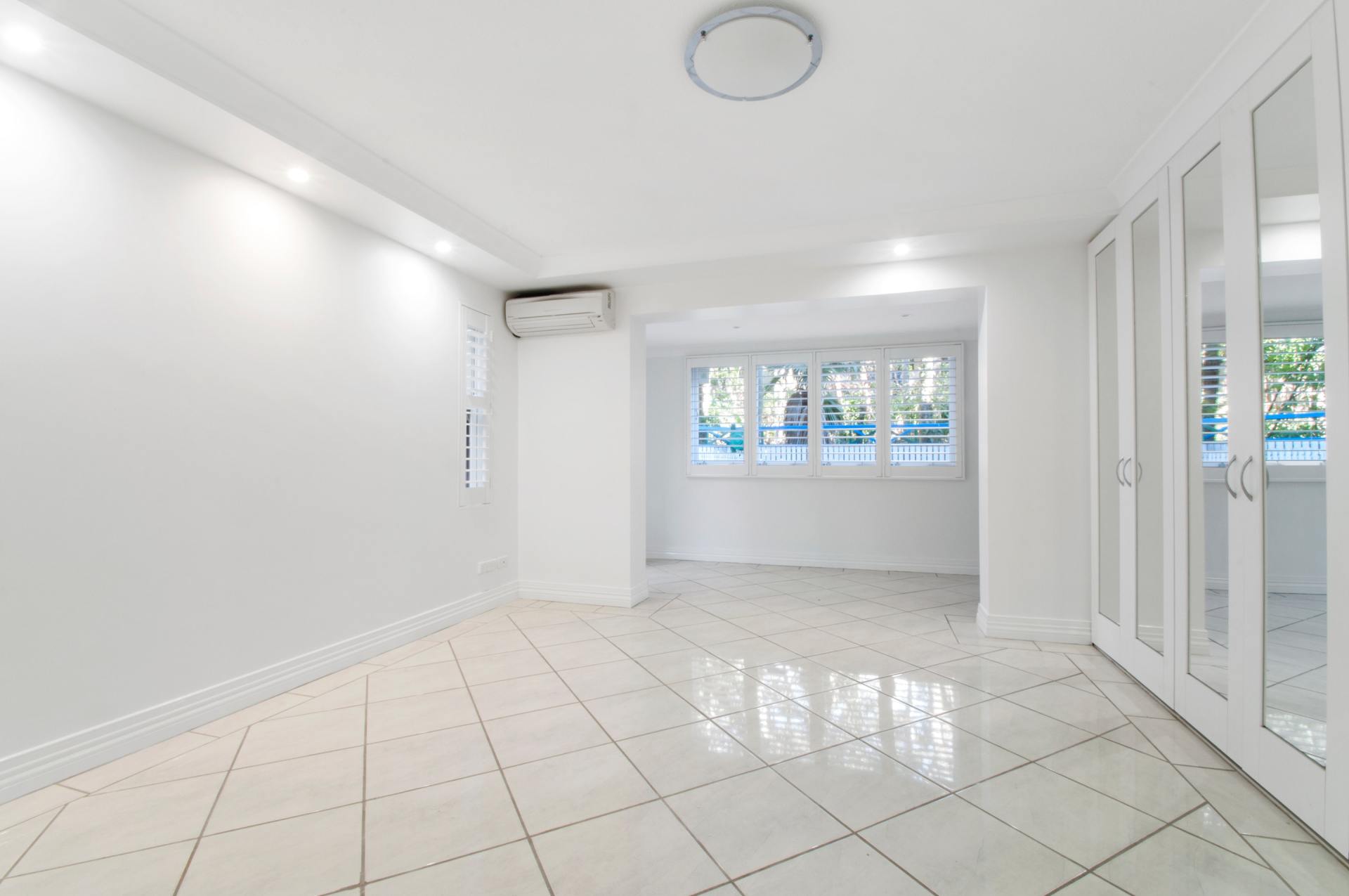 An empty room with white walls and a tiled floor.