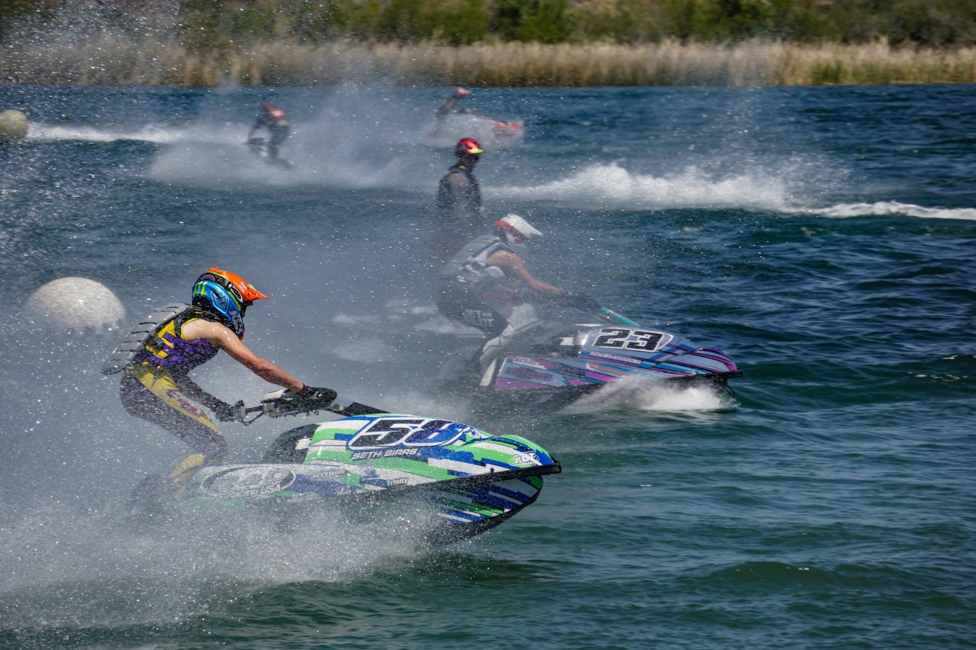 A group of people are riding jet skis on a lake.