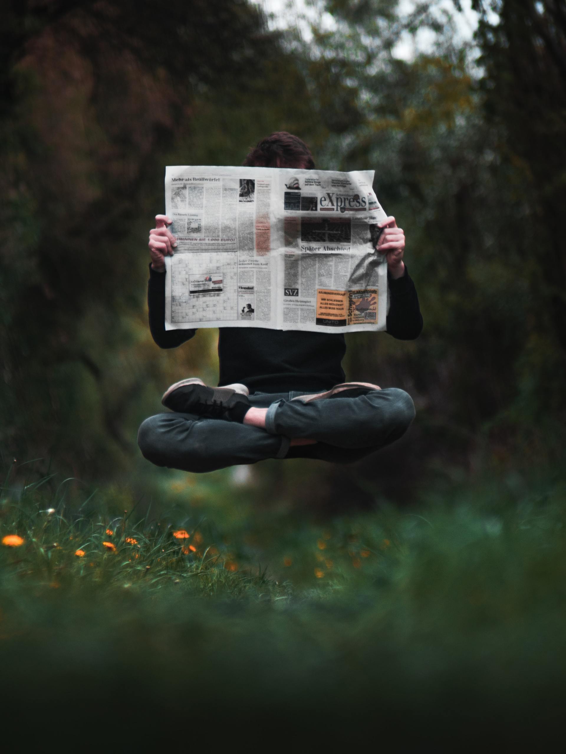 Levitating man reading delivered newspaper