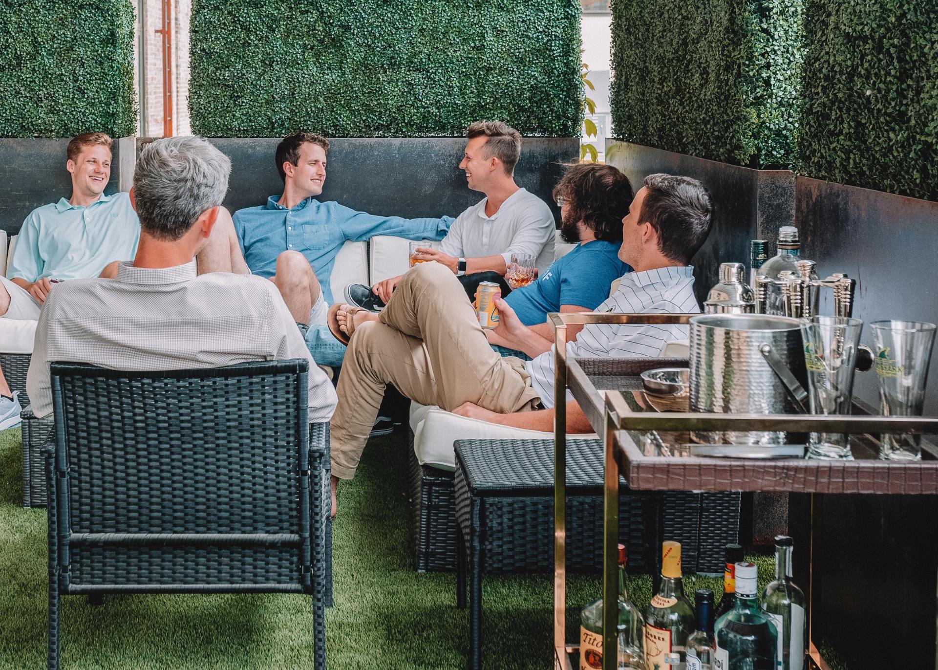 A group of men are sitting in chairs on a patio.