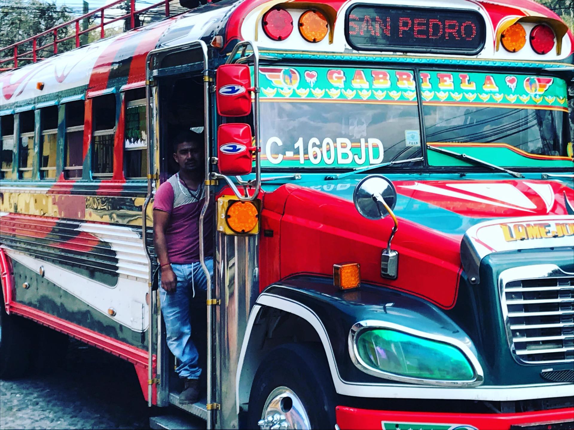 a man is getting off a colorful bus that says pedro on the front .