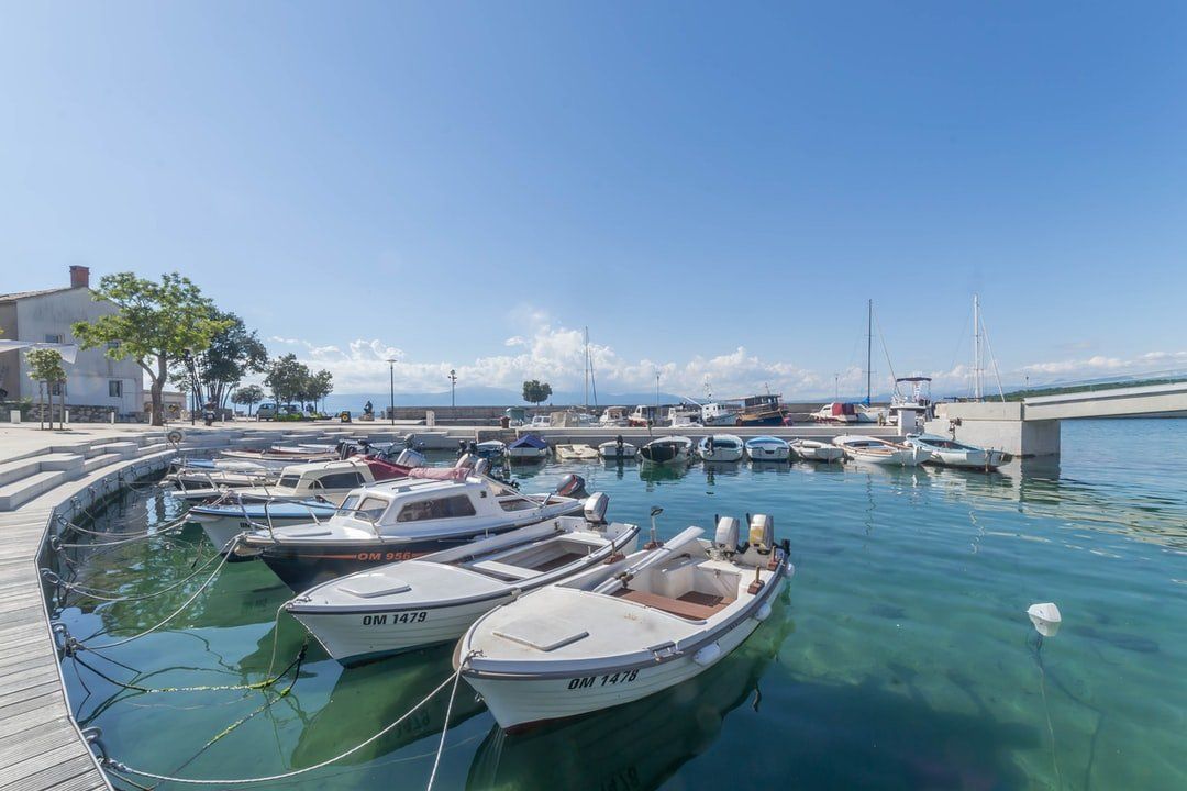 A group of boats are docked in a harbor.