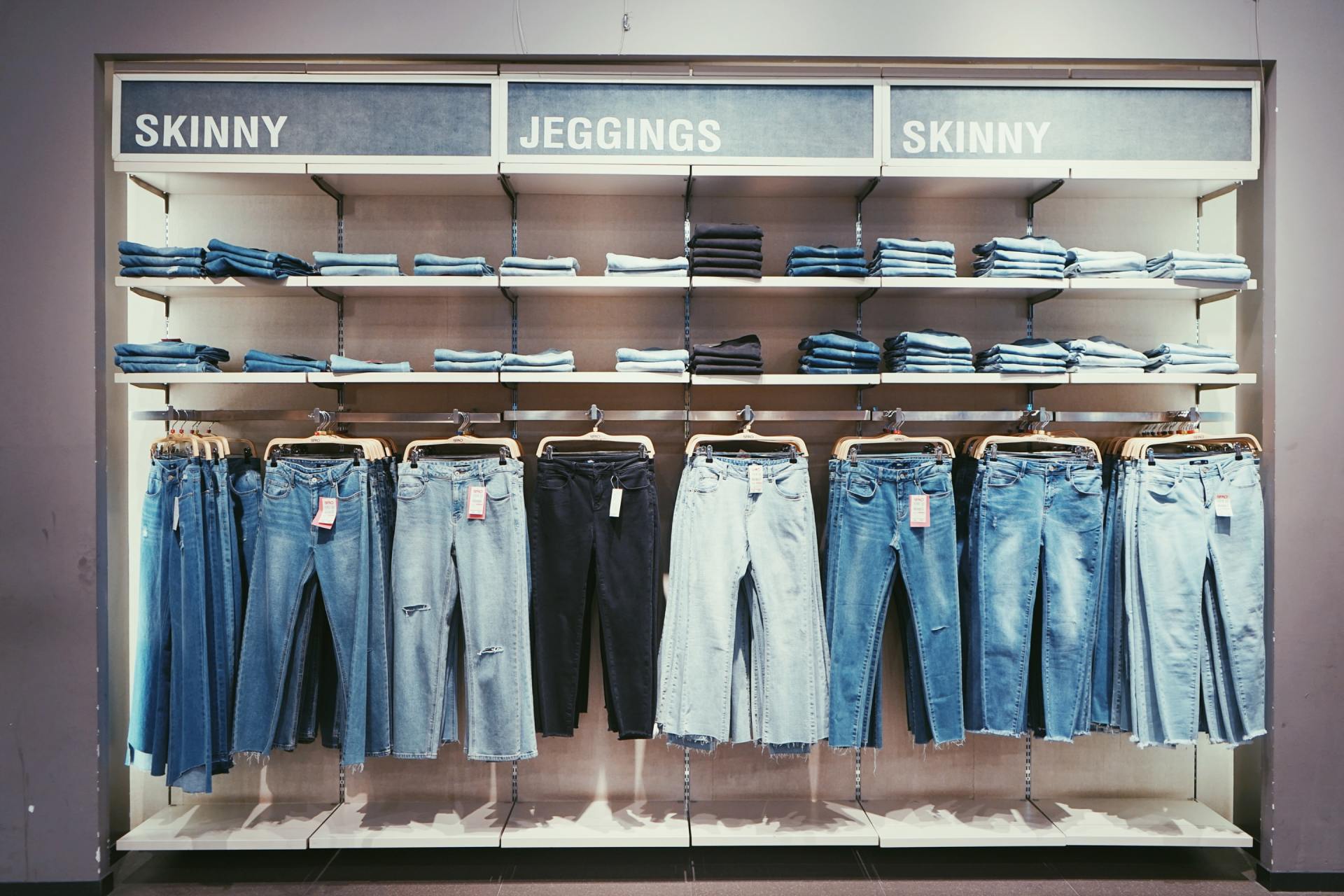 A row of jeans hanging on a rack in a store.