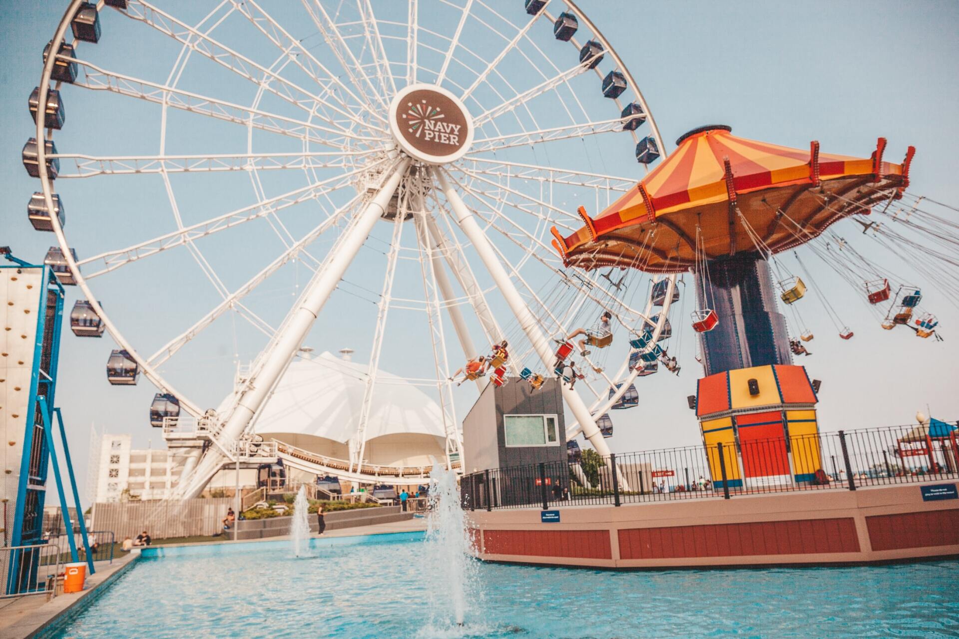 A ferris wheel and a swing ride in an amusement park.