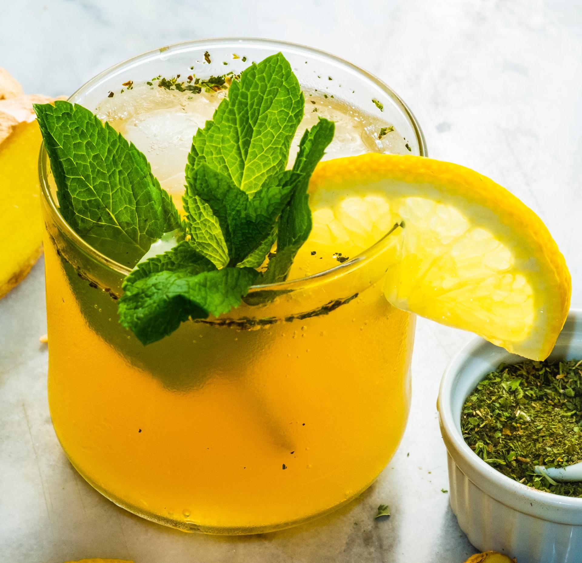 A glass of lemonade with mint leaves and a slice of lemon