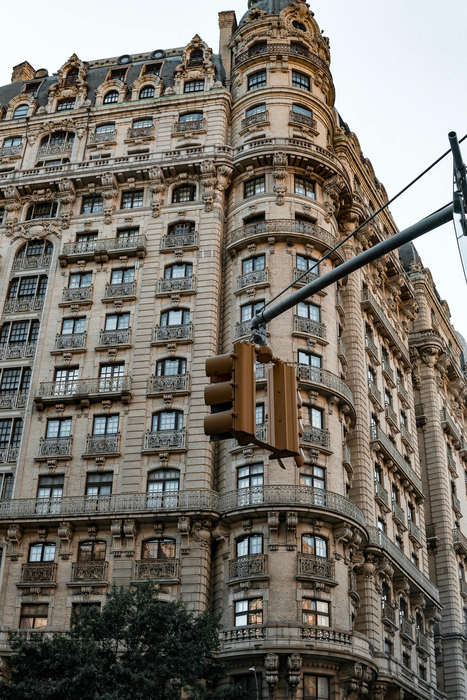 A traffic light is hanging from a pole in front of a large building.