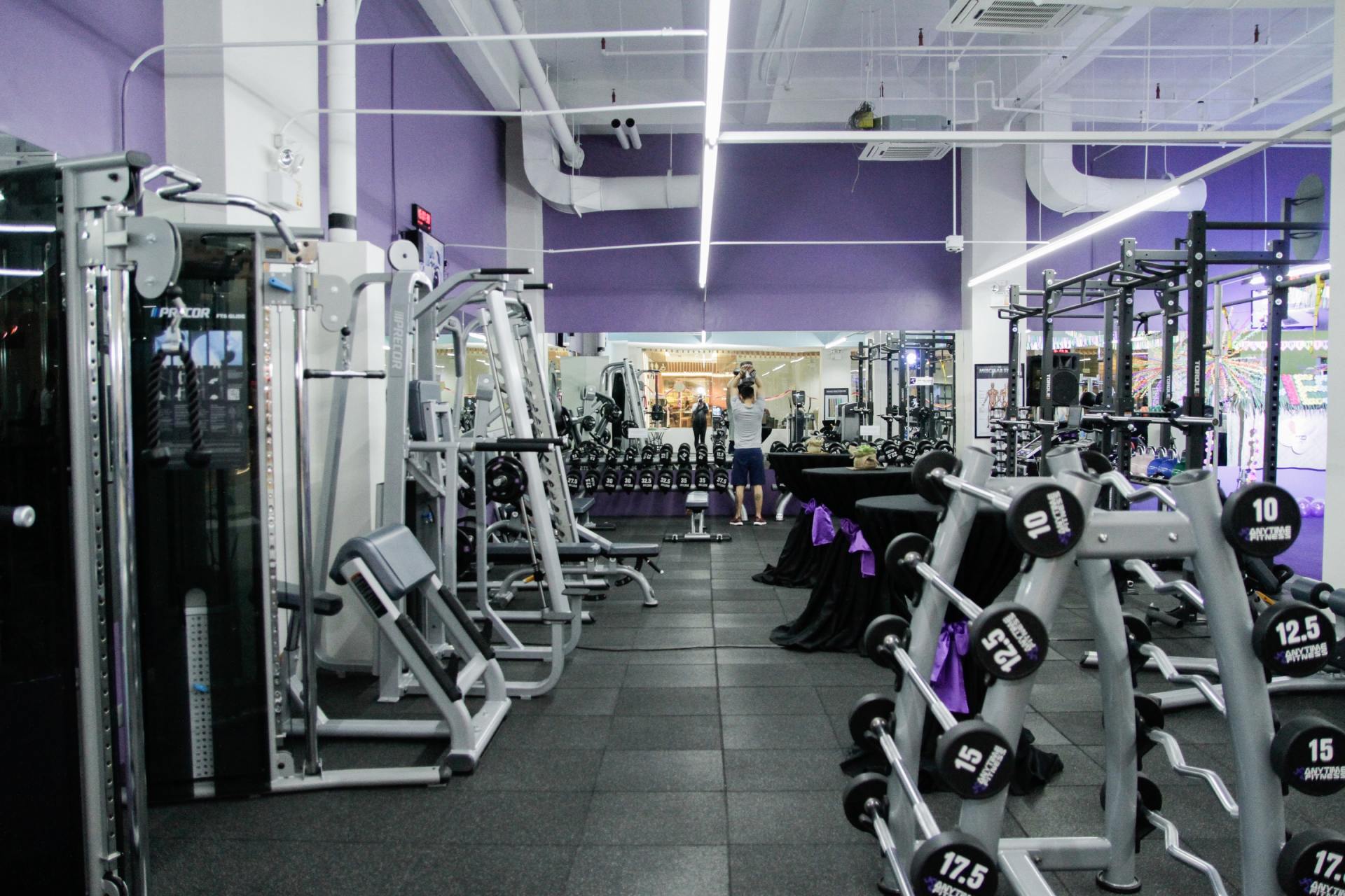 A gym with a lot of equipment and a purple wall.