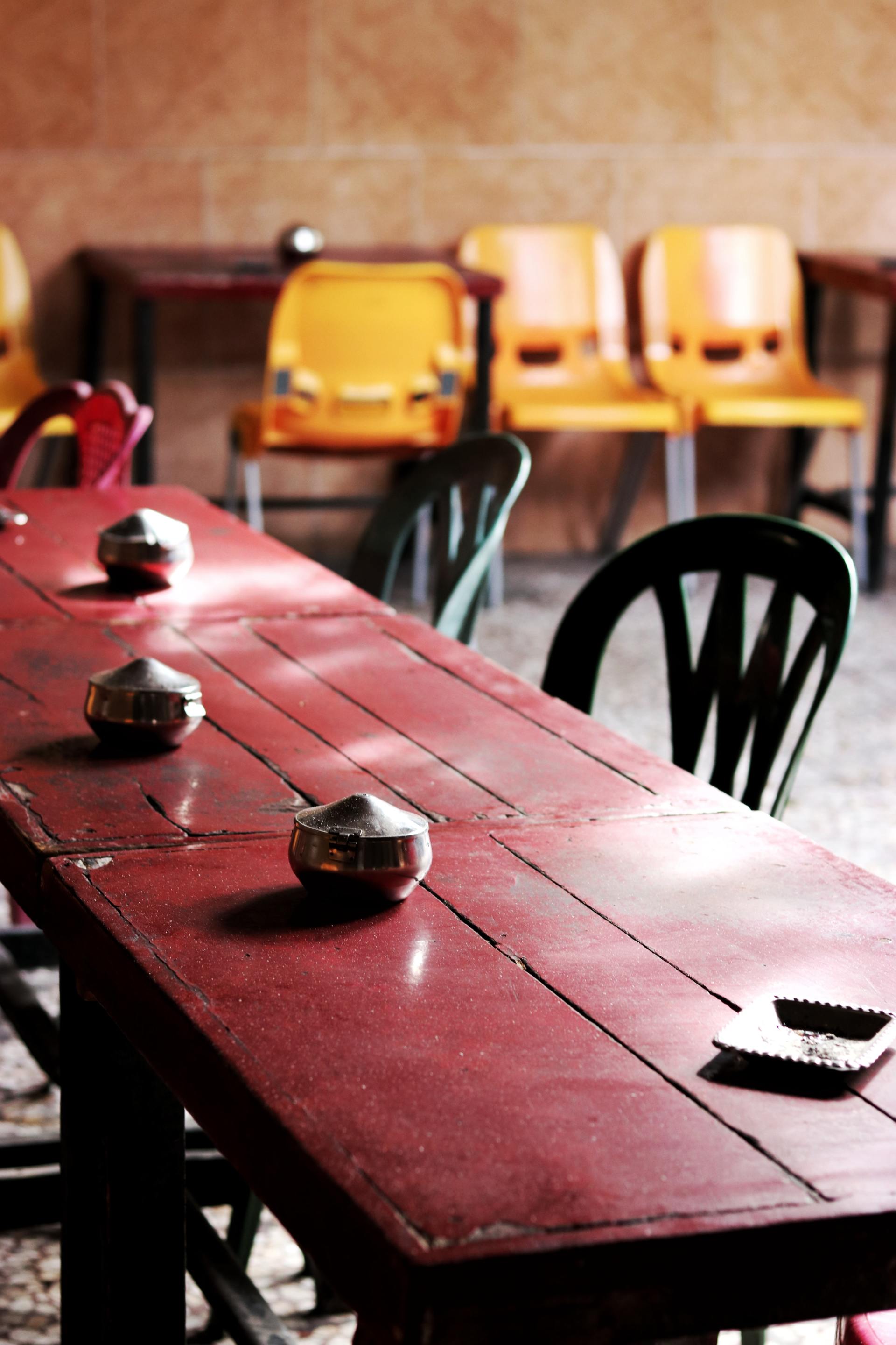A long red table with yellow chairs in a room