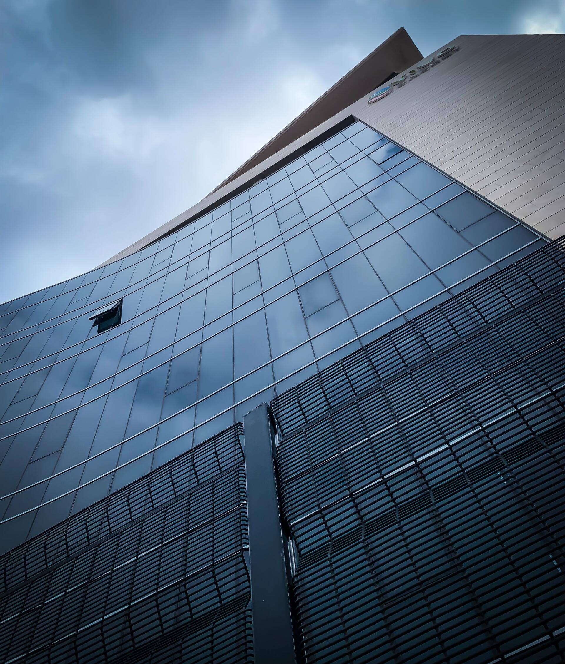 Large Office Building With The Sky & Clouds Reflecting off The Glass
