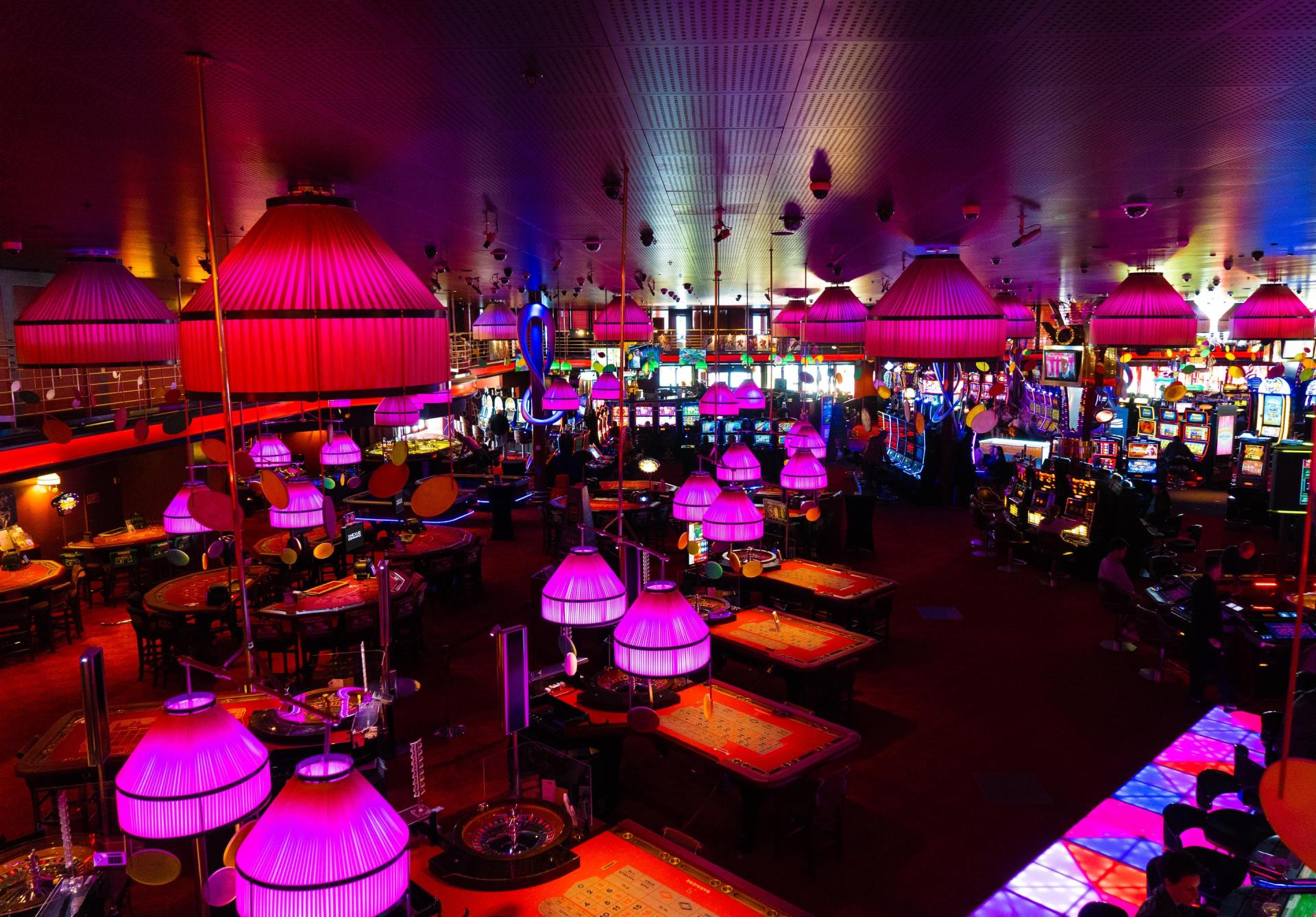 A casino with lots of tables and purple lights