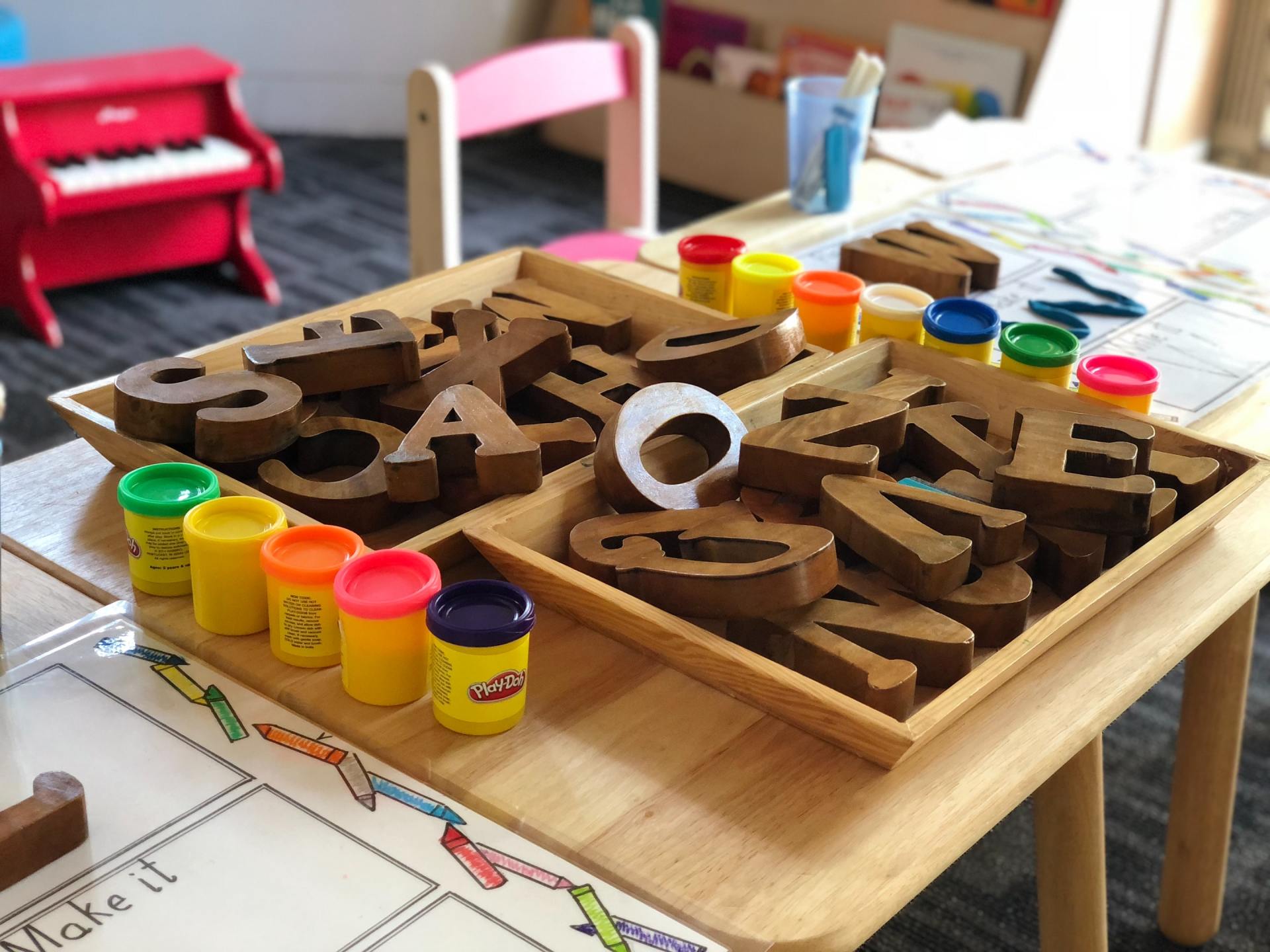 Plastilina y juguetes con letras del alfabeto en la mesa del aula