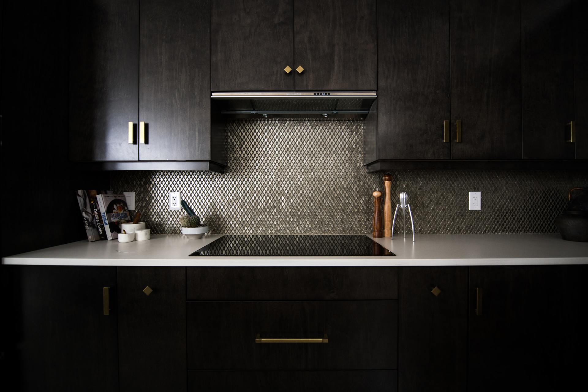 black kitchen with metallic hardware and tile backsplash
