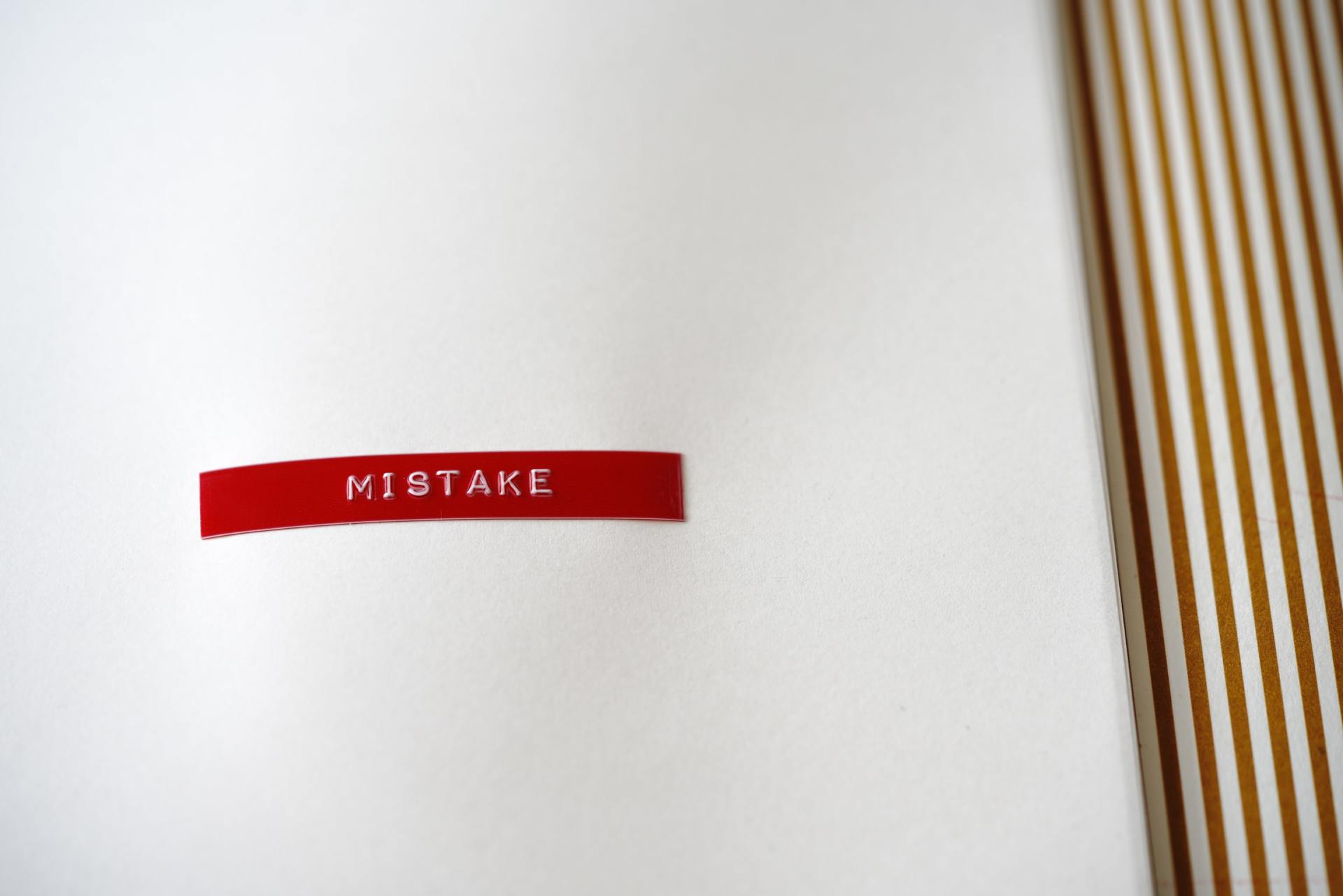 a white piece of paper with a red label that says mistake