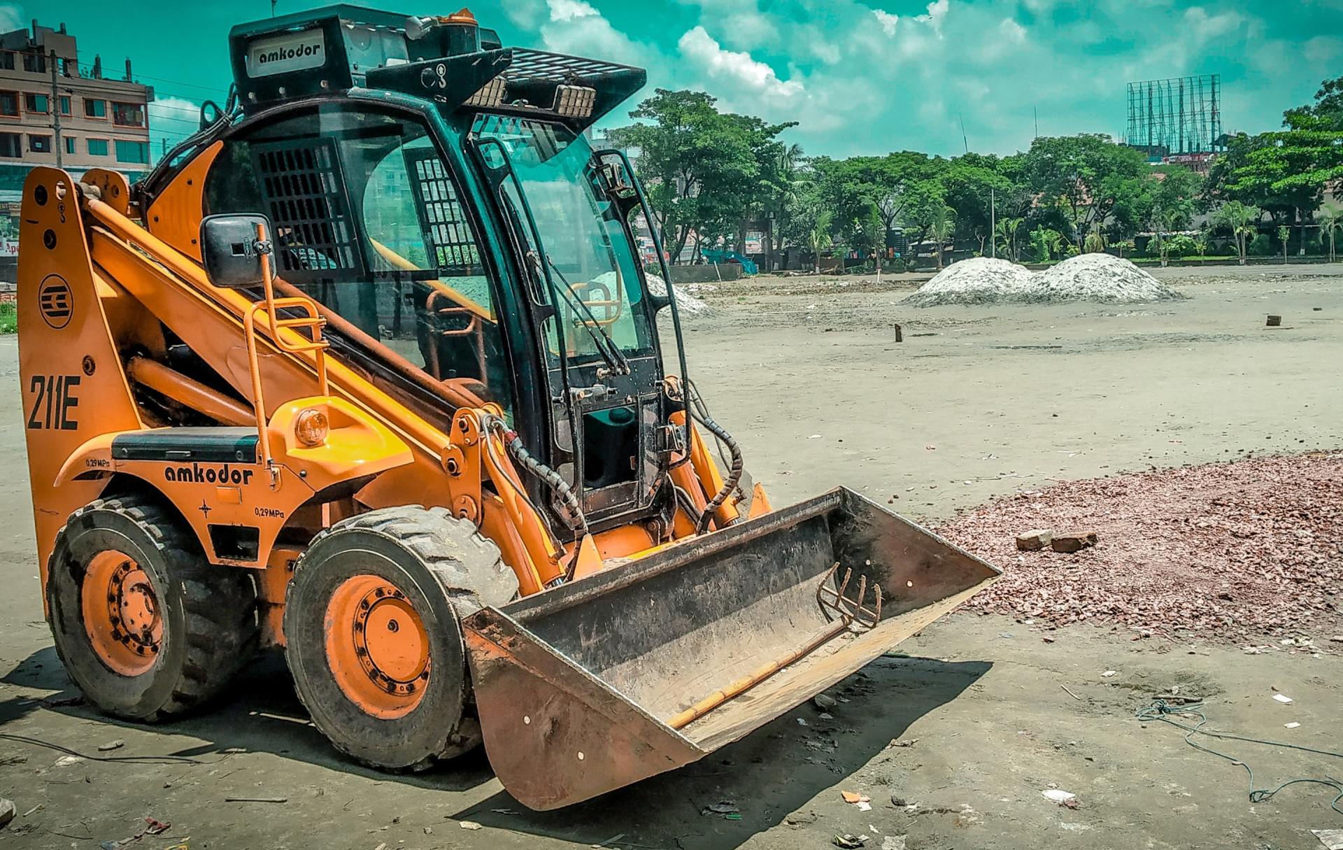 A small bulldozer is parked in a dirt field.