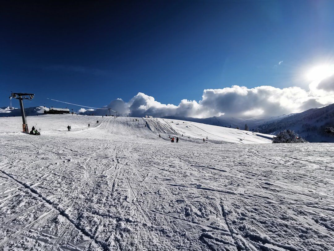 A snowy ski slope with a ski lift in the background