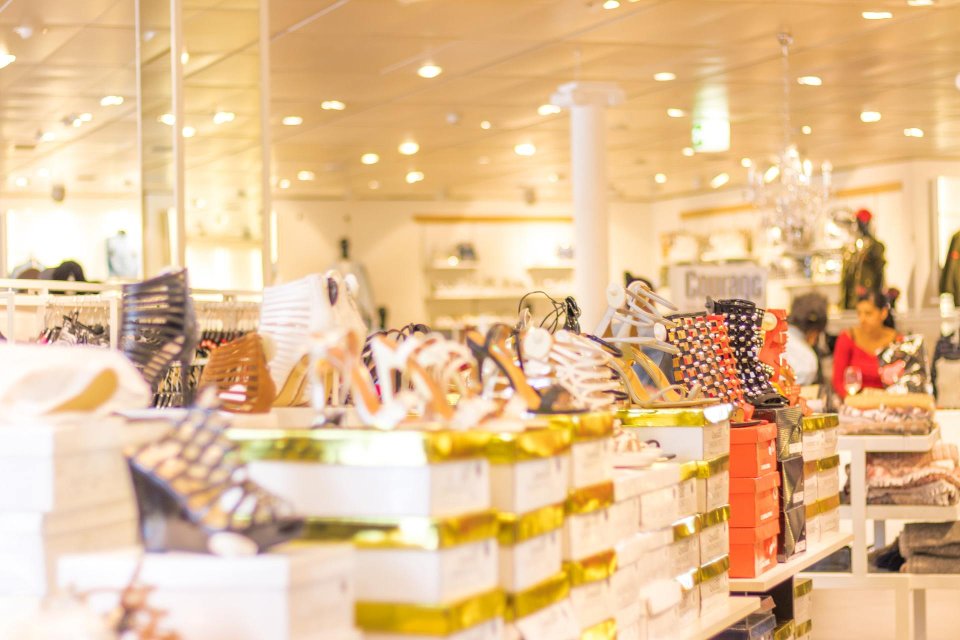 A blurred image of a shoe store filled with lots of shoes.