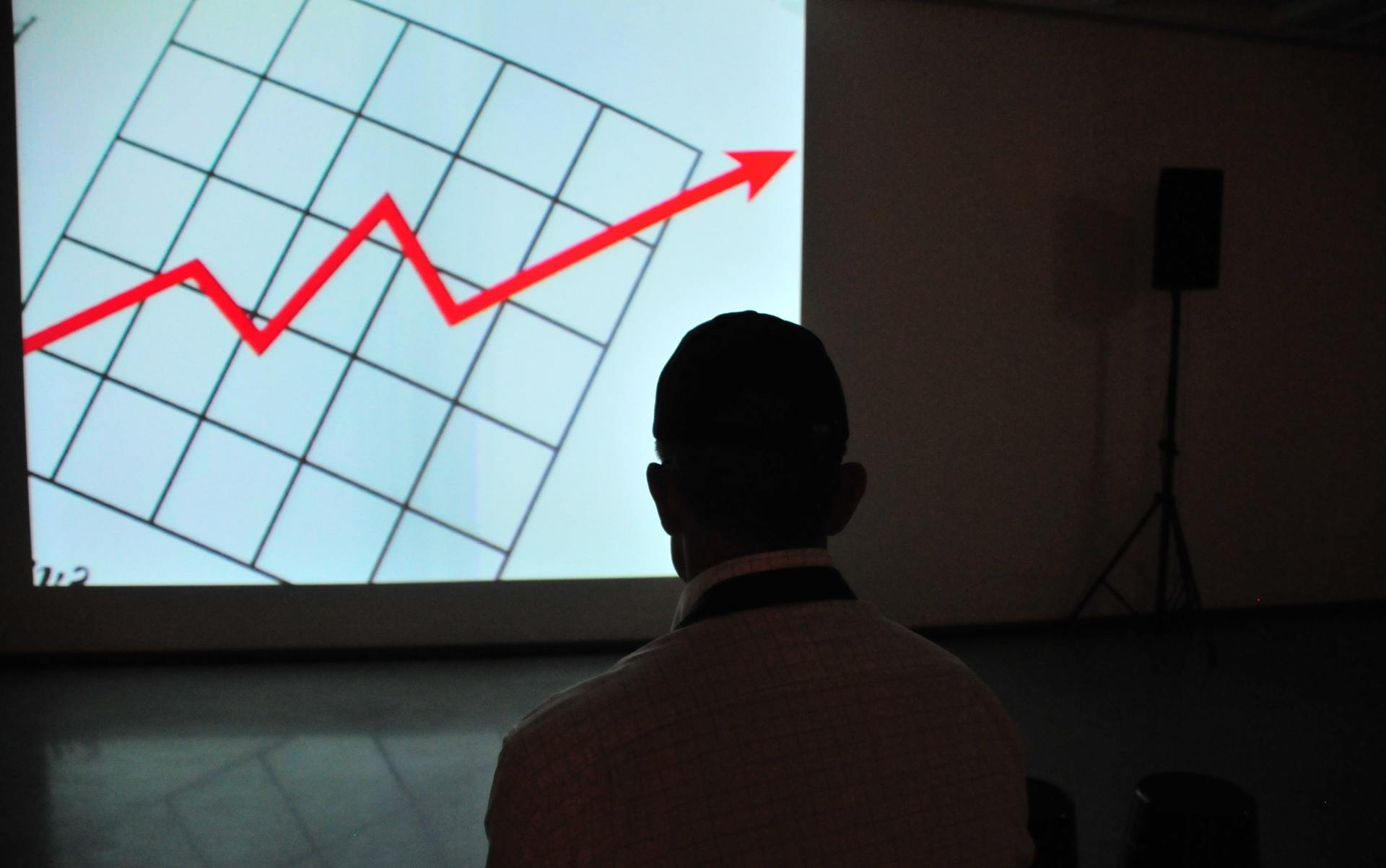 A man standing in front of a graph in a meeting