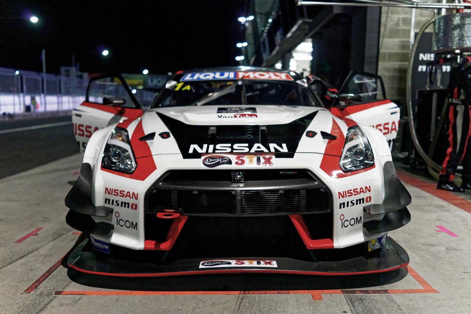 A nissan race car is parked in a garage