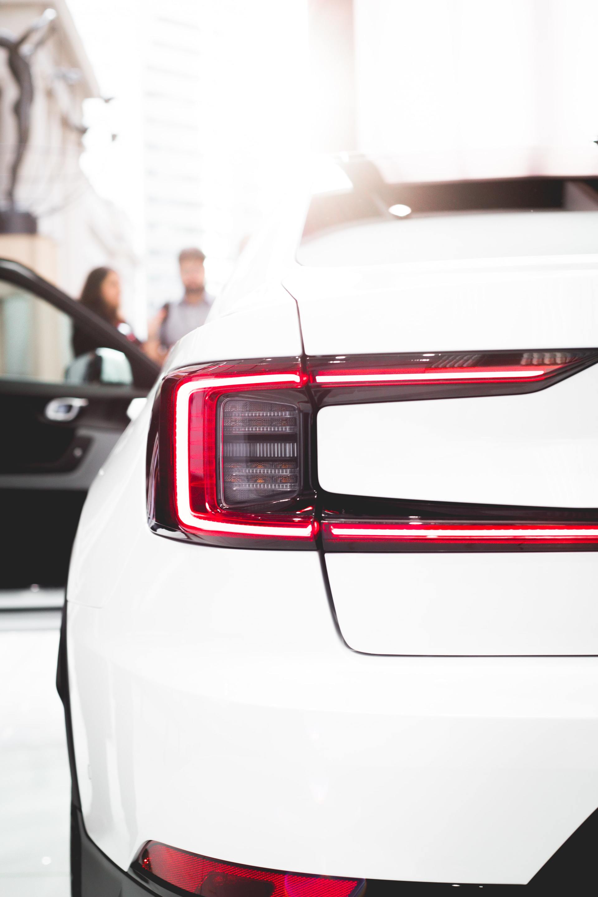 Un primo piano di un'auto bianca con una luce posteriore rossa.