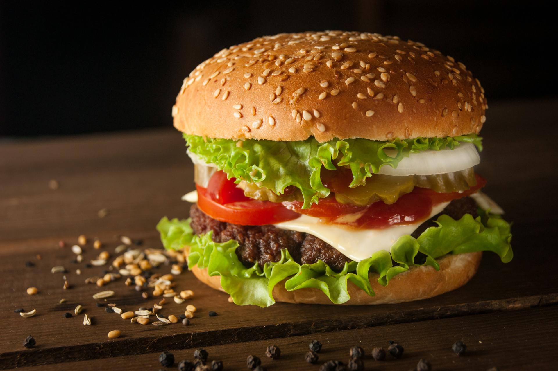 A close up of a hamburger on a wooden table.