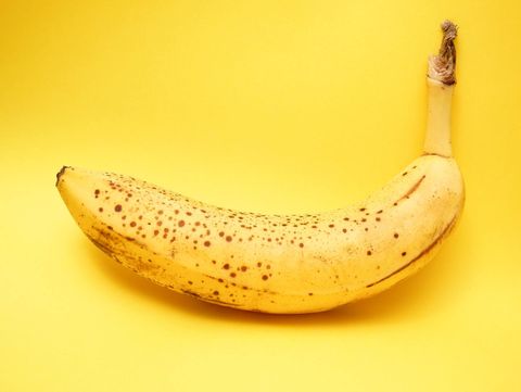 very ripe banana on bright yellow background