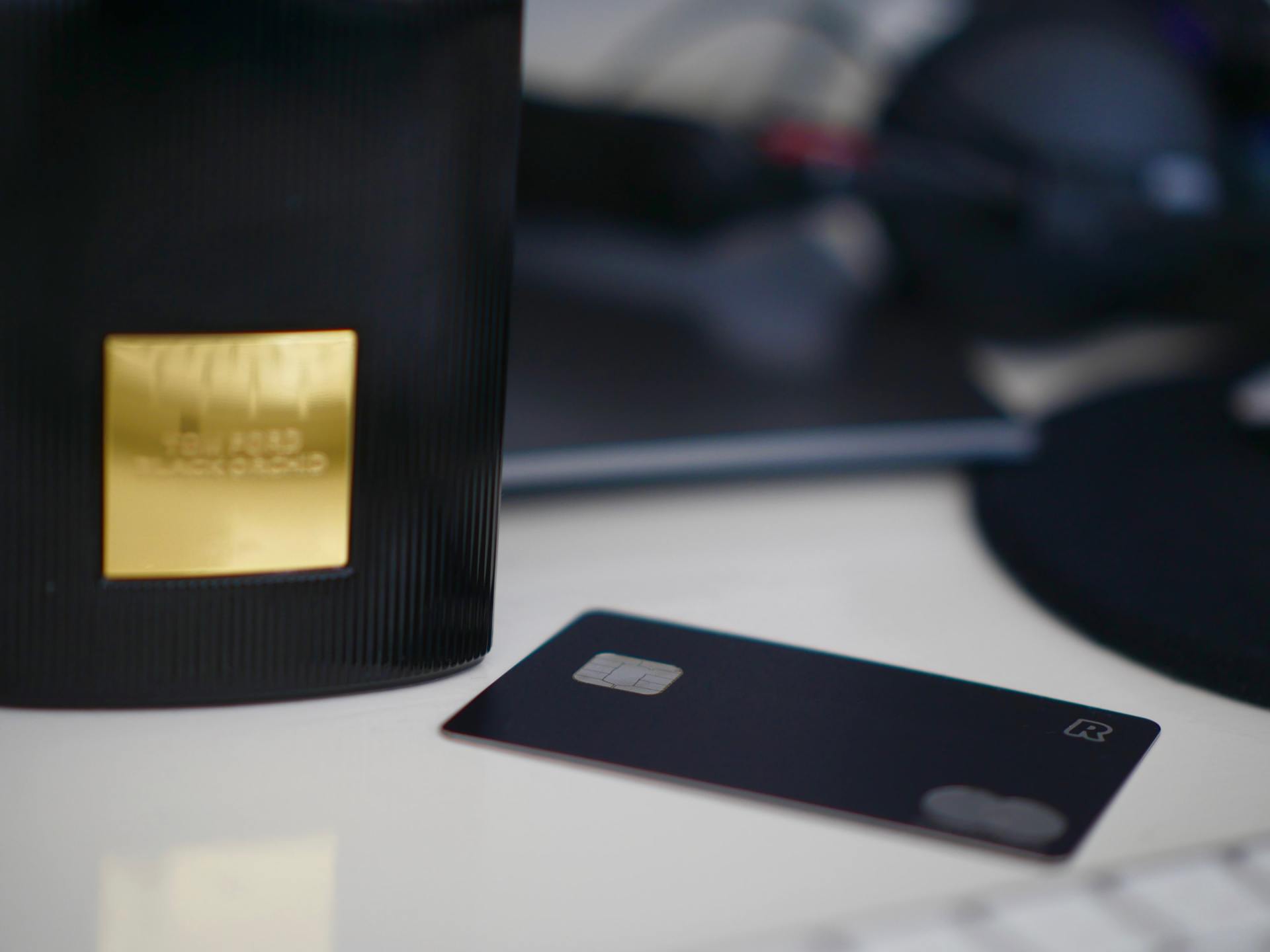A black credit card is sitting on a table next to a black box.