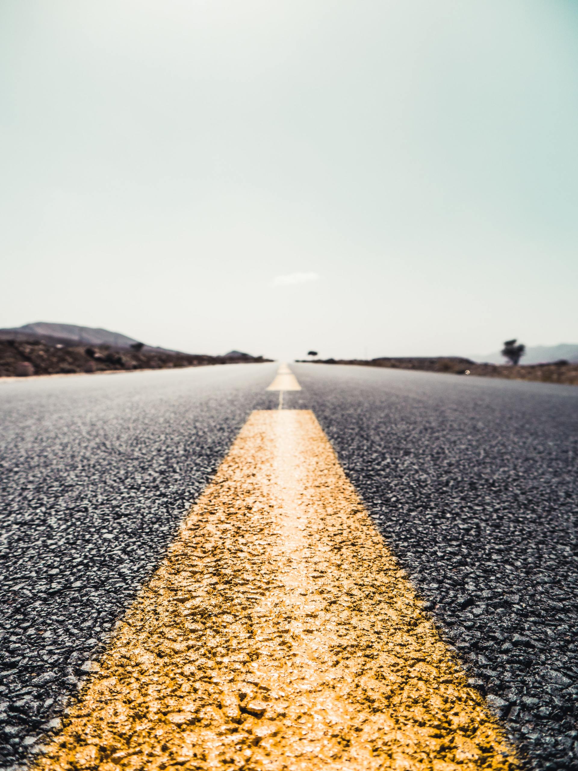 A close up of a road with a yellow line on it.