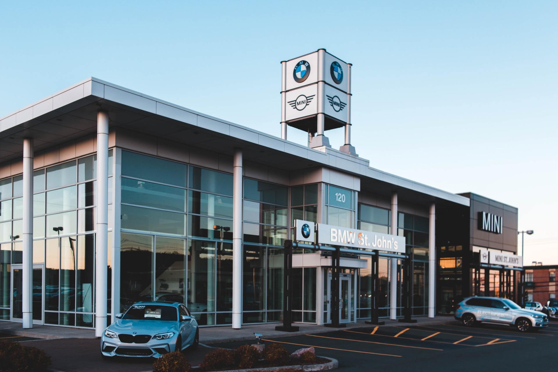 A car is parked in front of a bmw dealership.