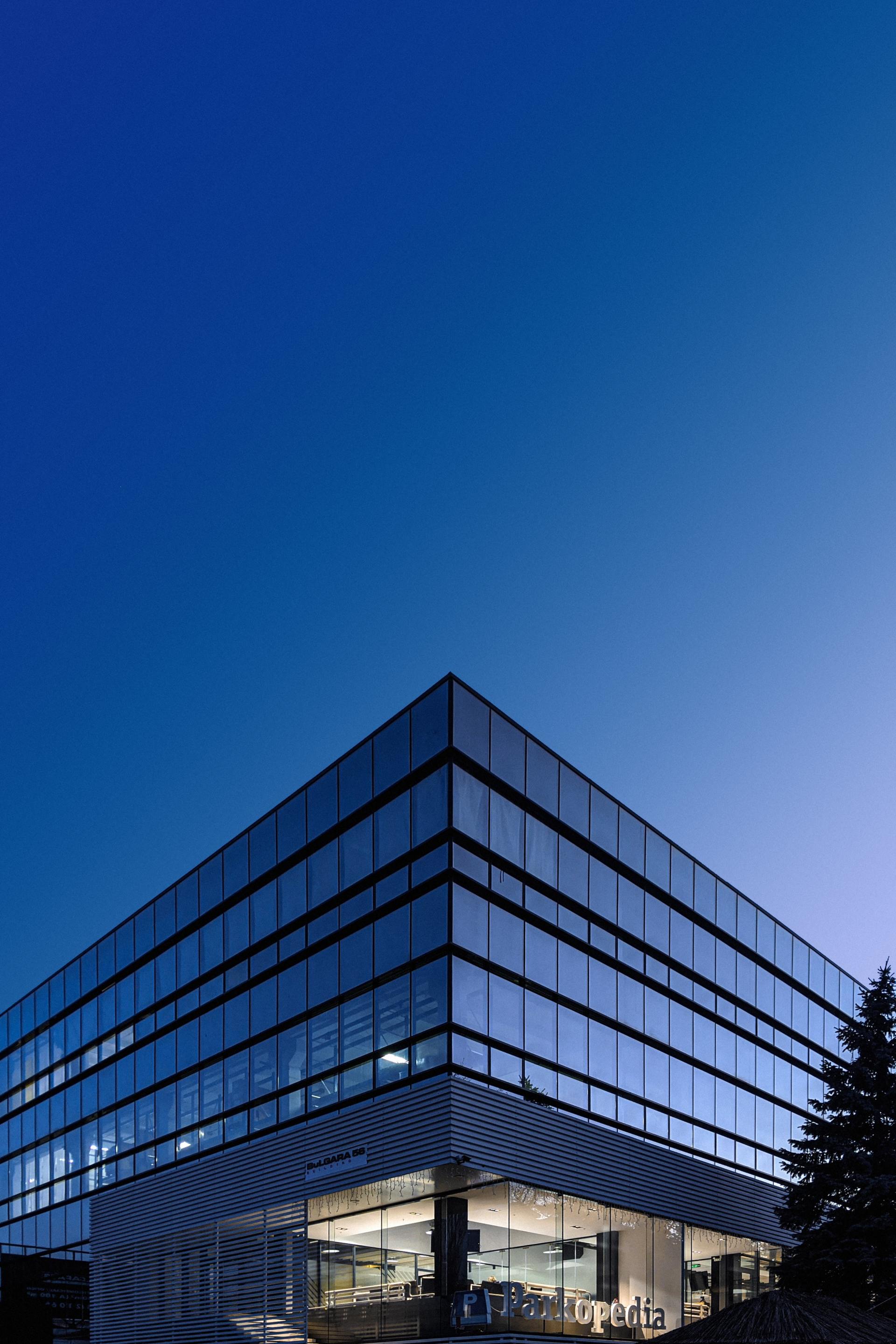A large glass building with a blue sky in the background