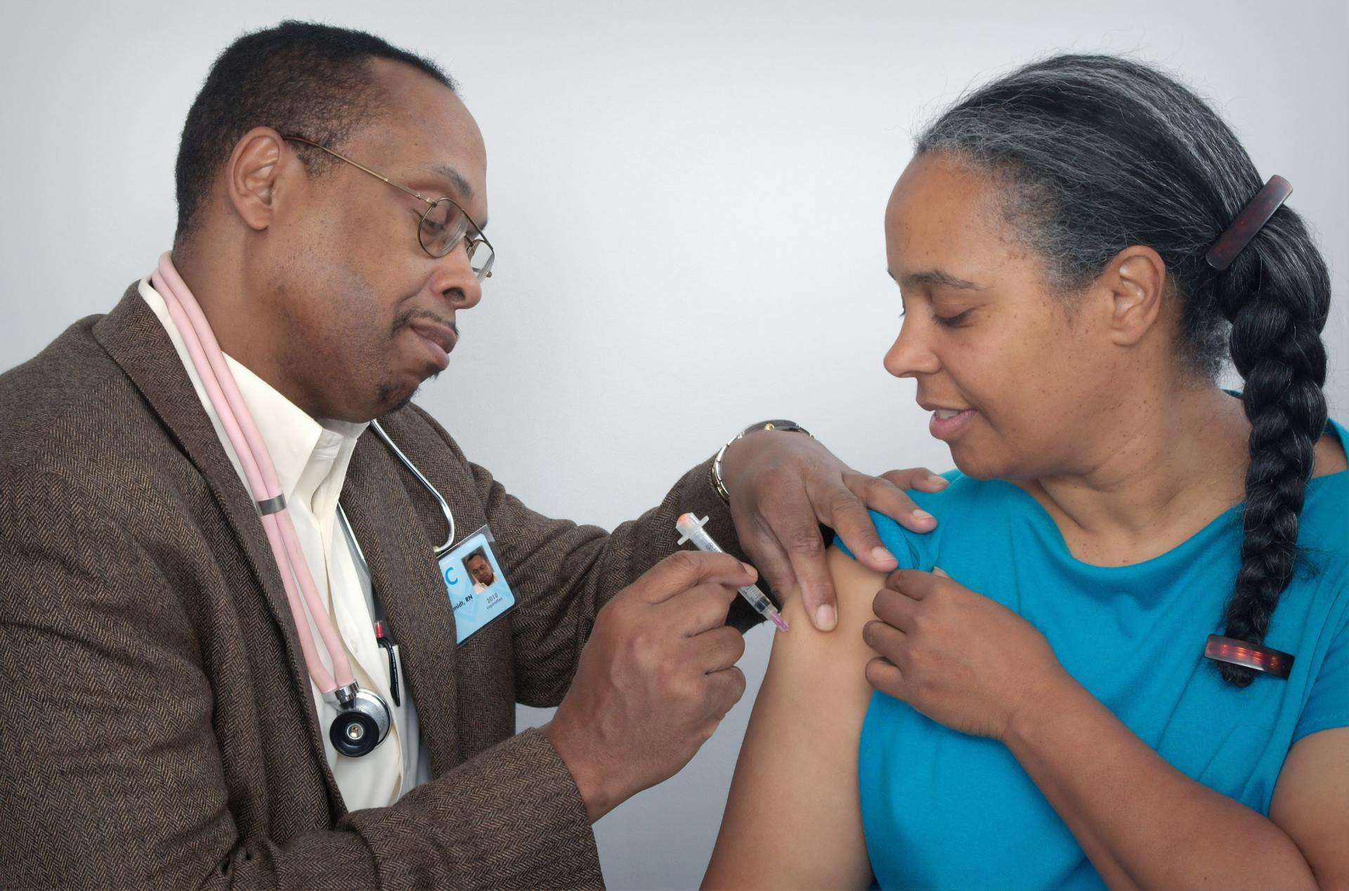 A doctor is giving a woman an injection in her arm