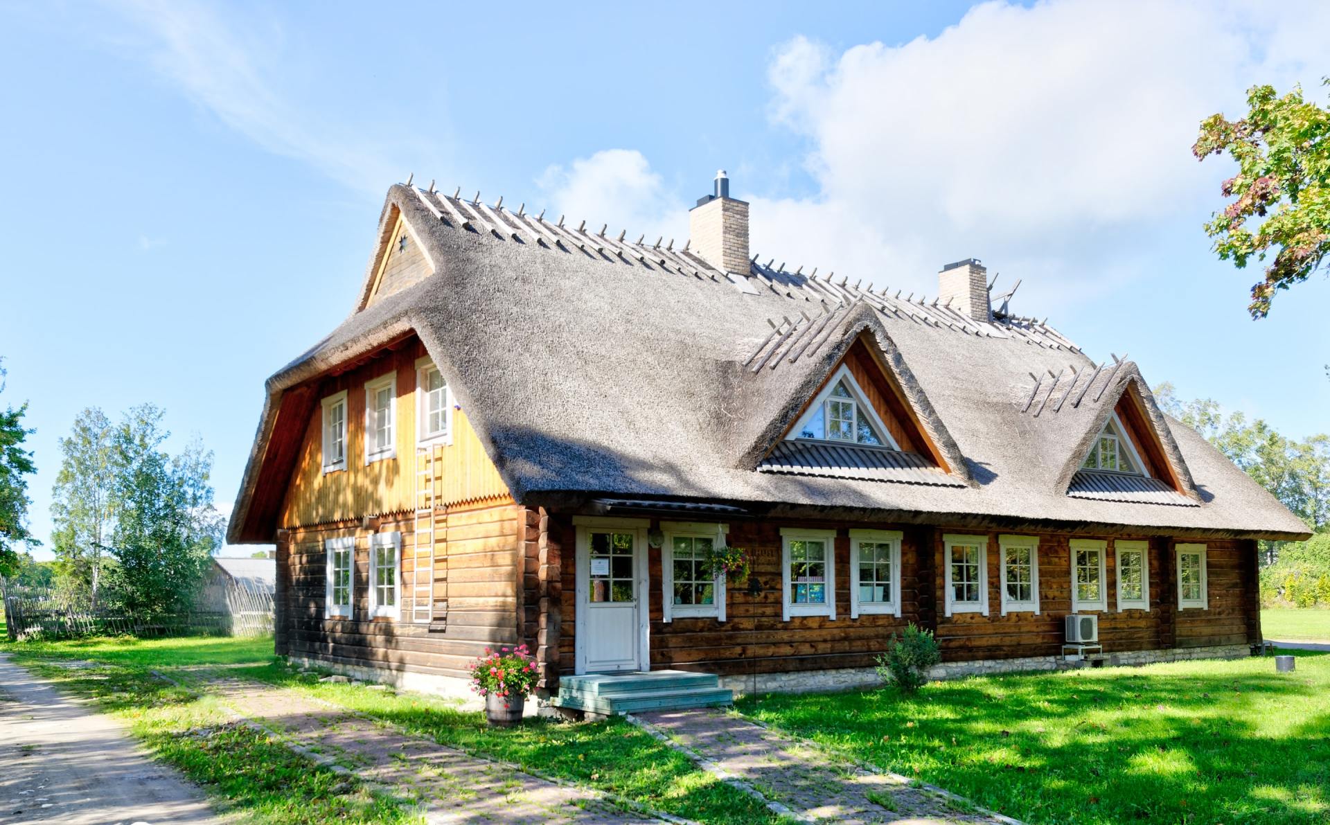 A large wooden house with a thatched roof