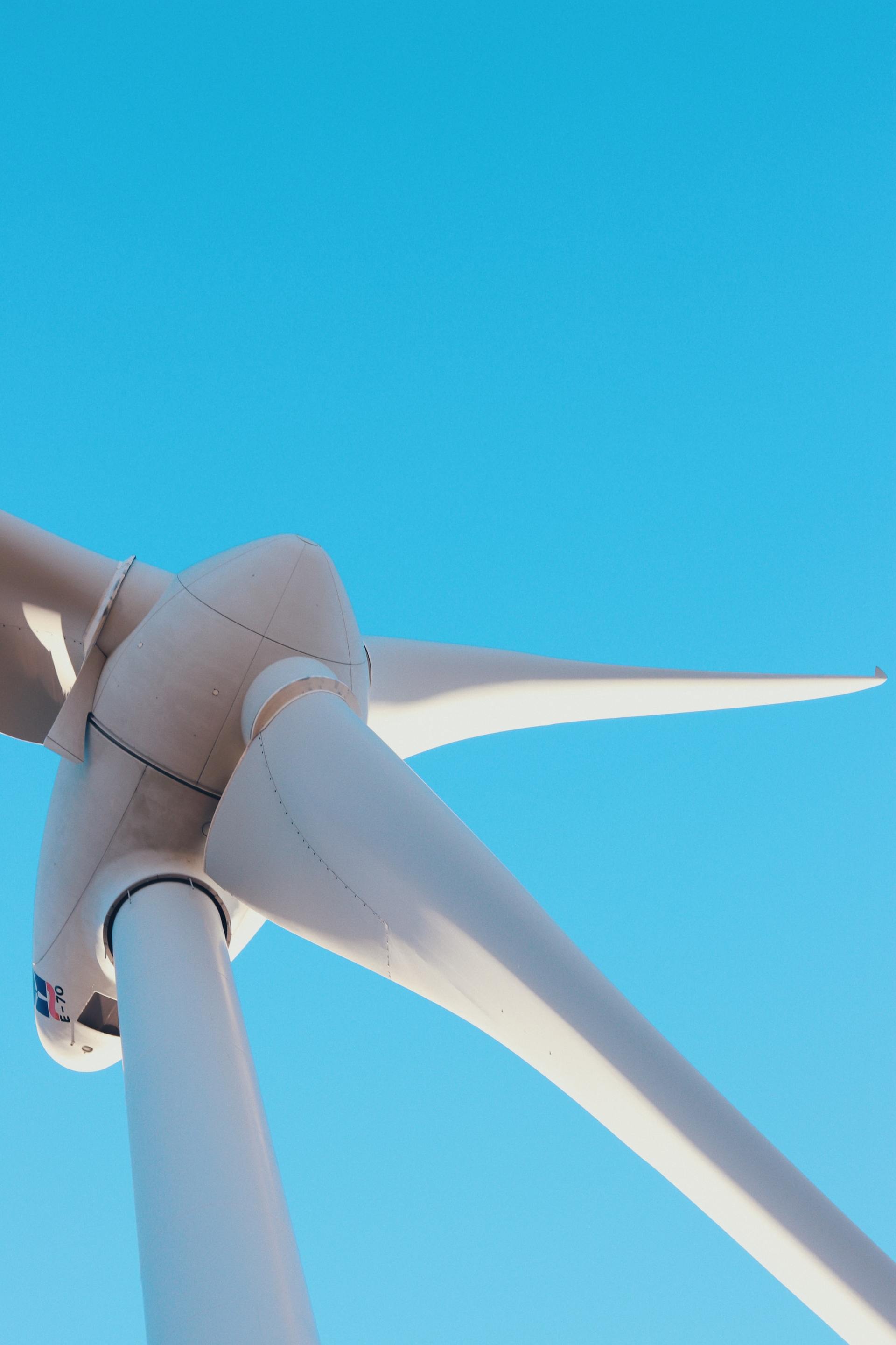 A close up of a wind turbine against a blue sky