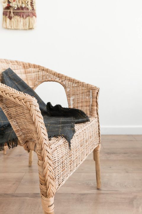 wicker chair with a gray blanket on it
