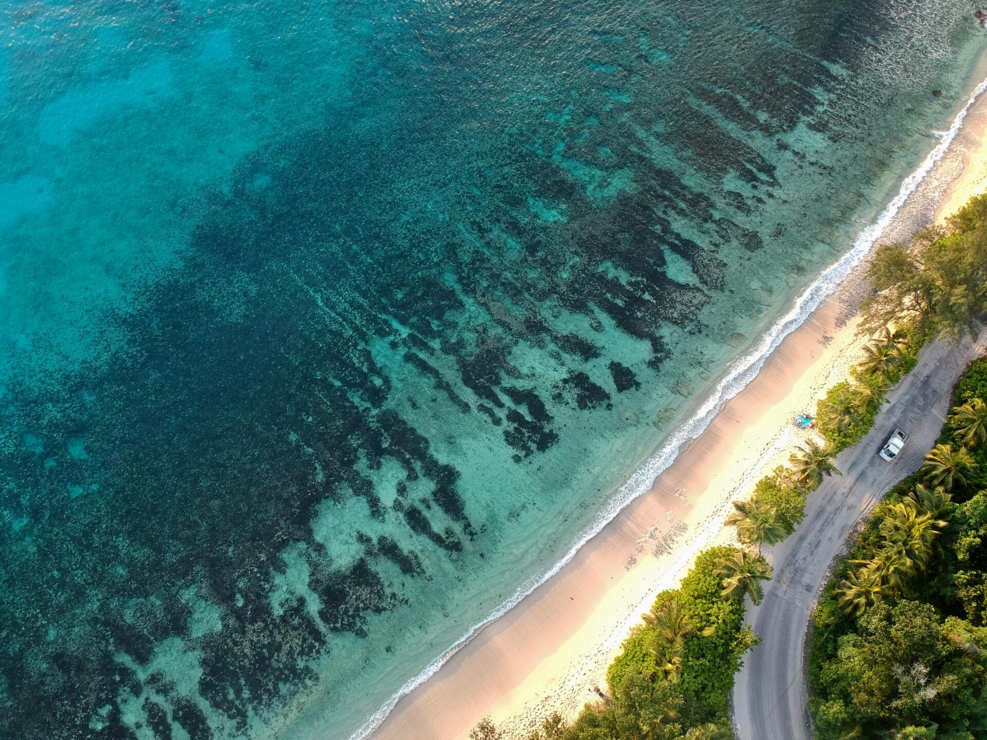 Eine Luftaufnahme eines Strandes, durch den eine Straße führt.