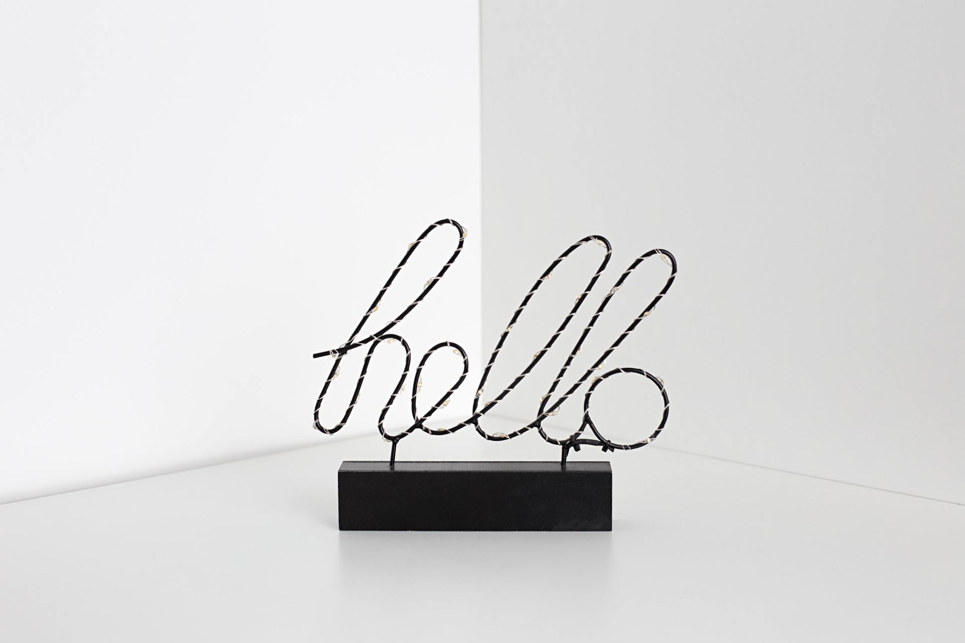 A black sign that says hello on a white background