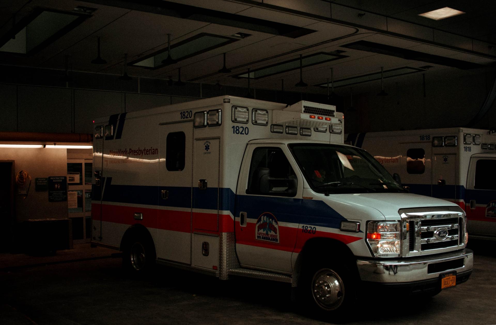 An ambulance is parked in a dark garage.