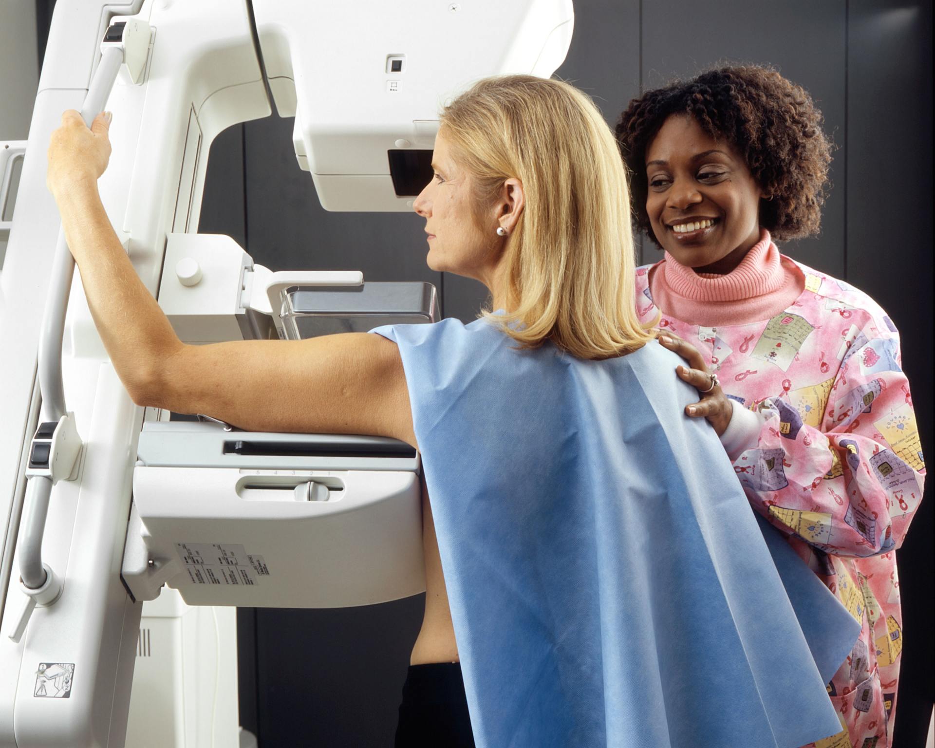 A woman is getting her breast examined by a doctor