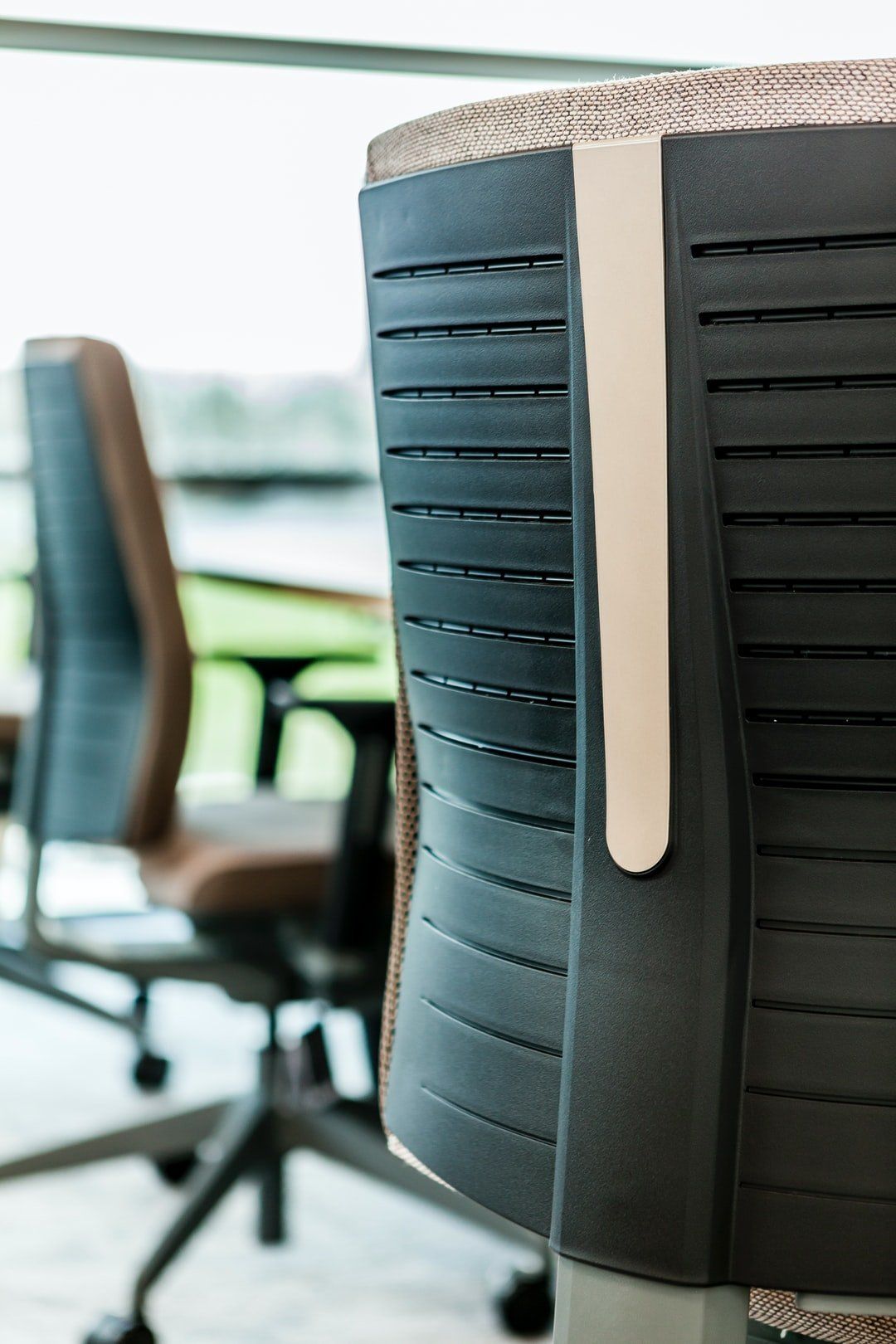 close up shot of the back of three office chairs at a conference table