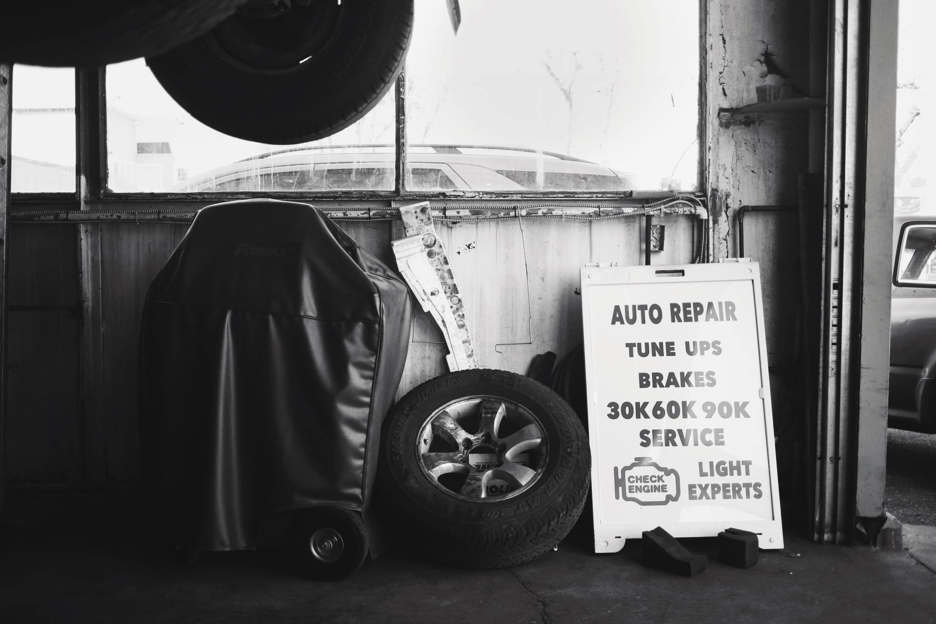 A black and white photo of a garage with a sign that says auto repair