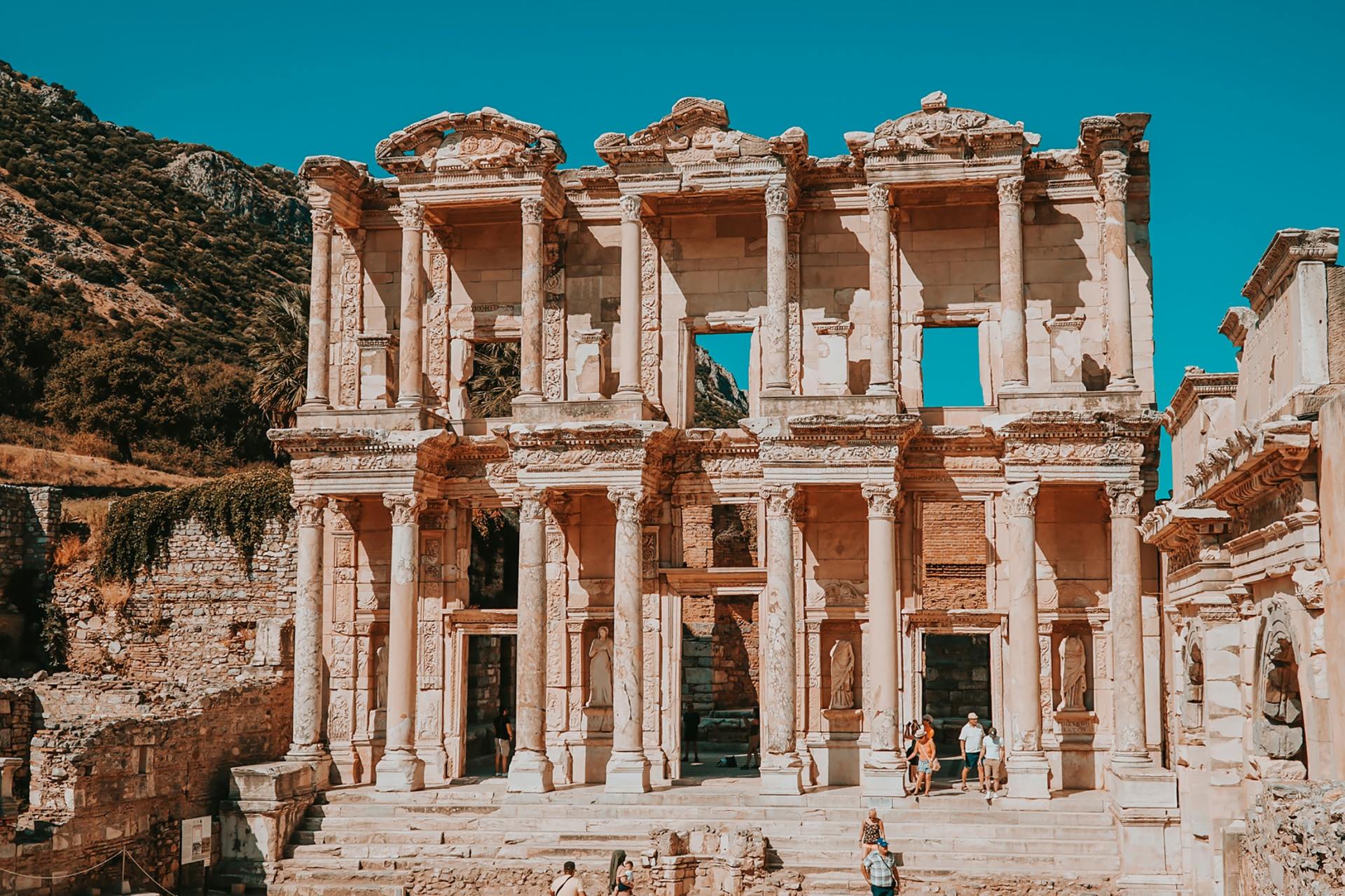 A group of people are standing in front of an ancient building.