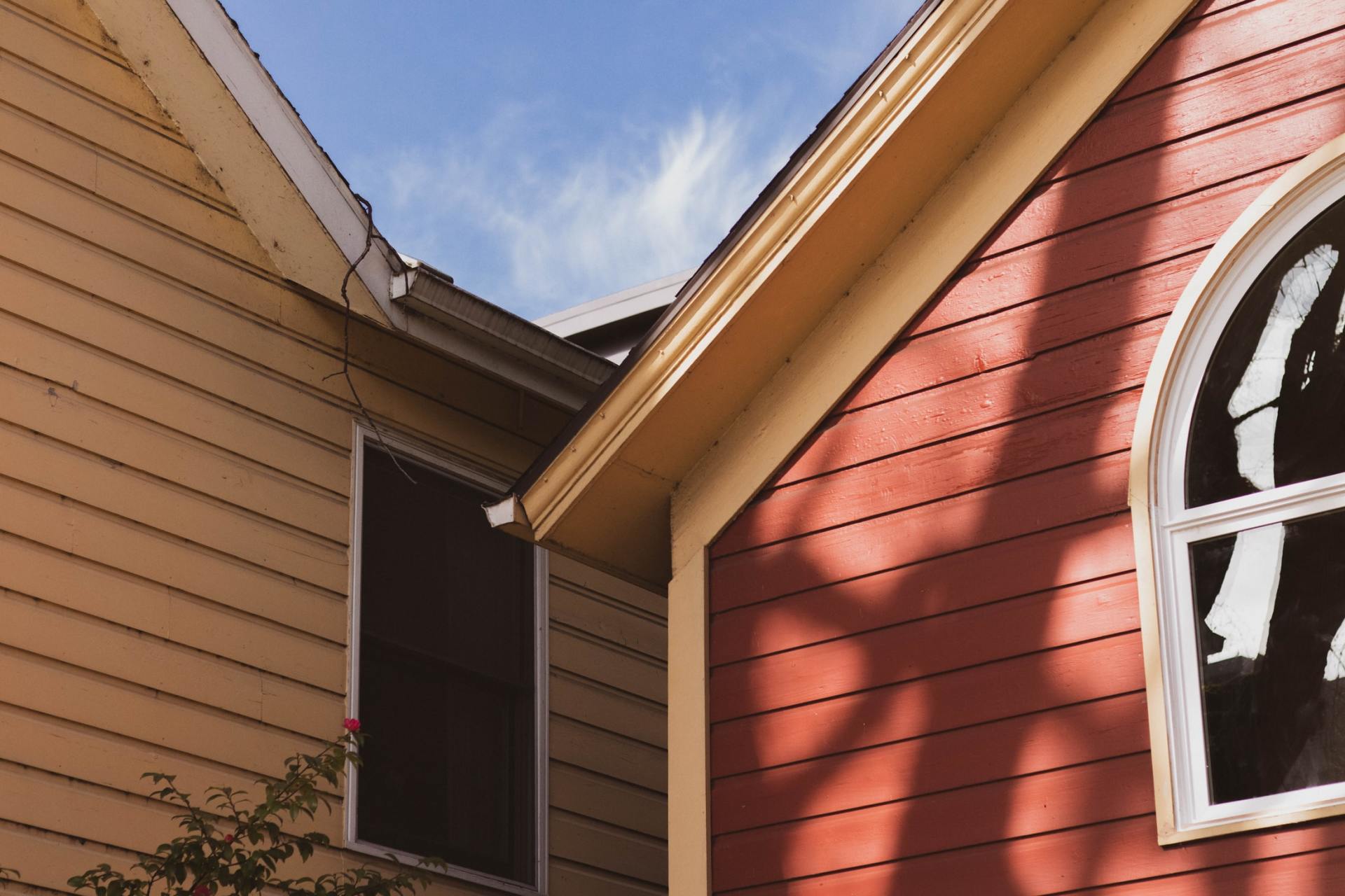 A red building with a window and a shadow on it