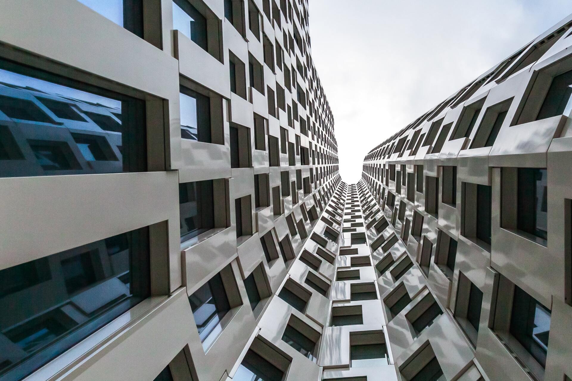 Looking up at a very tall building with lots of windows
