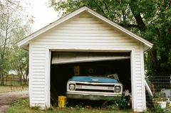 a blue chevrolet truck is parked in a garage